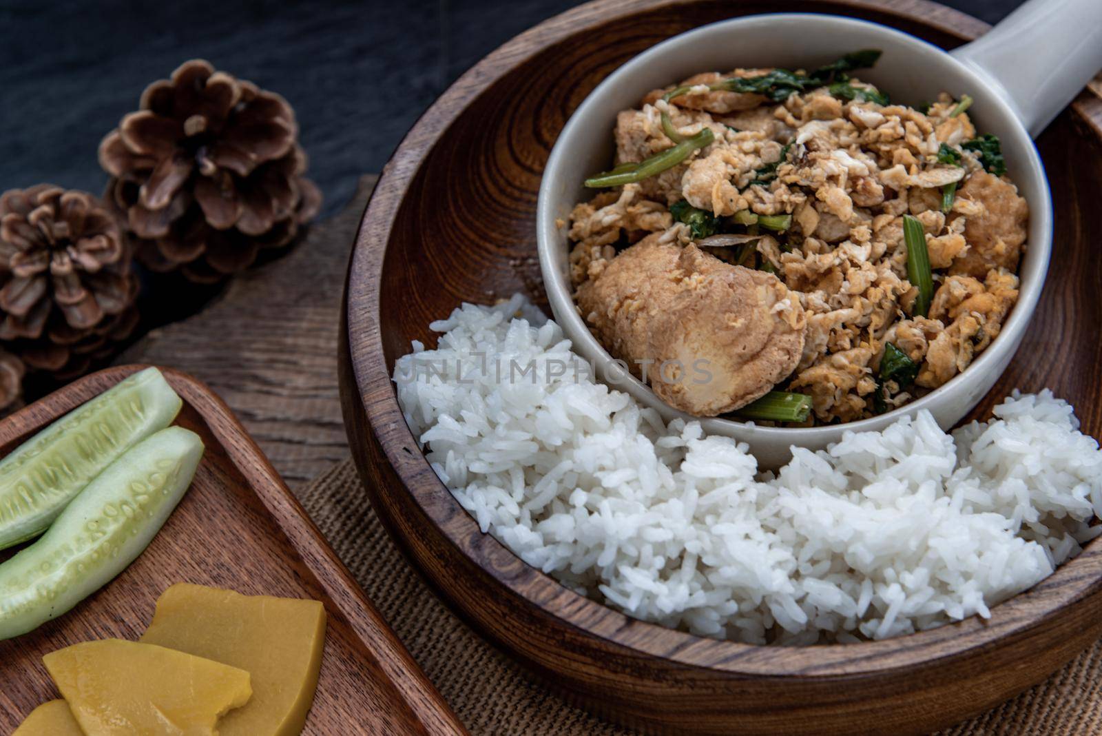 Thai food, Stir fried egg tofu with spring onion with Herbs vegetables served with steamed rice in wooden bowl, Oblique view from the top.