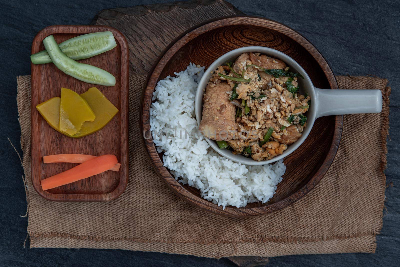 Thai food, Stir fried egg tofu with spring onion with Herbs vegetables served with steamed rice in wooden bowl, view from above.