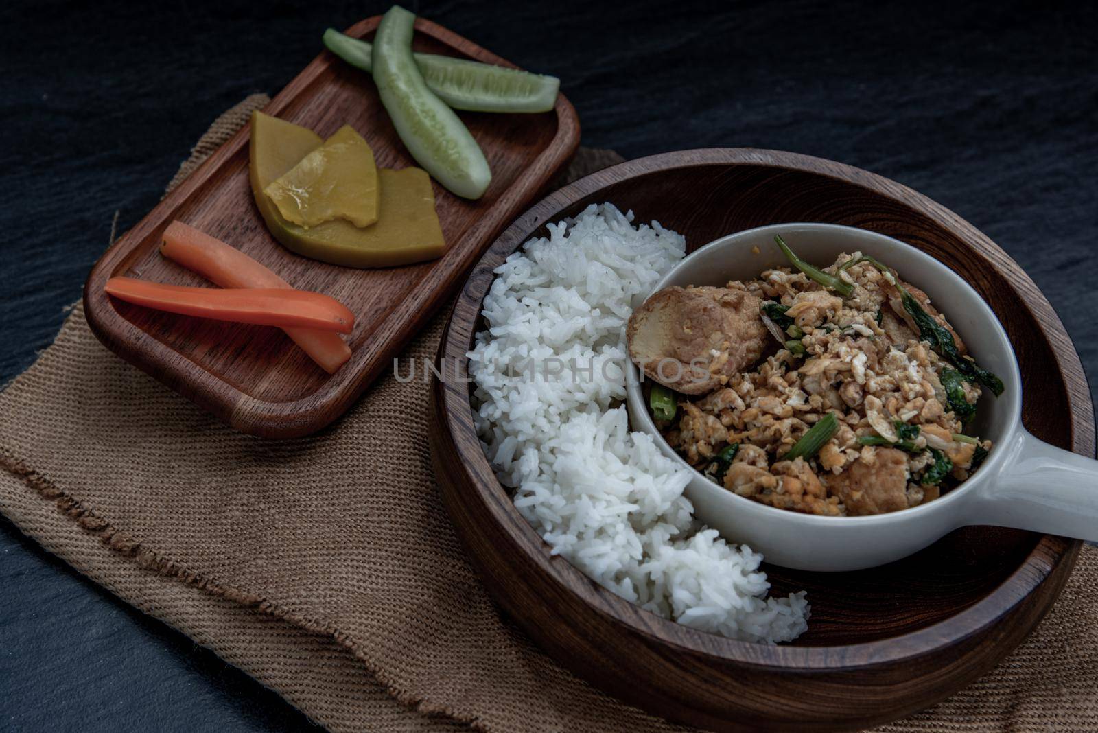 Thai food, Stir fried egg tofu with spring onion with Herbs vegetables served with steamed rice in wooden bowl, Oblique view from the top.