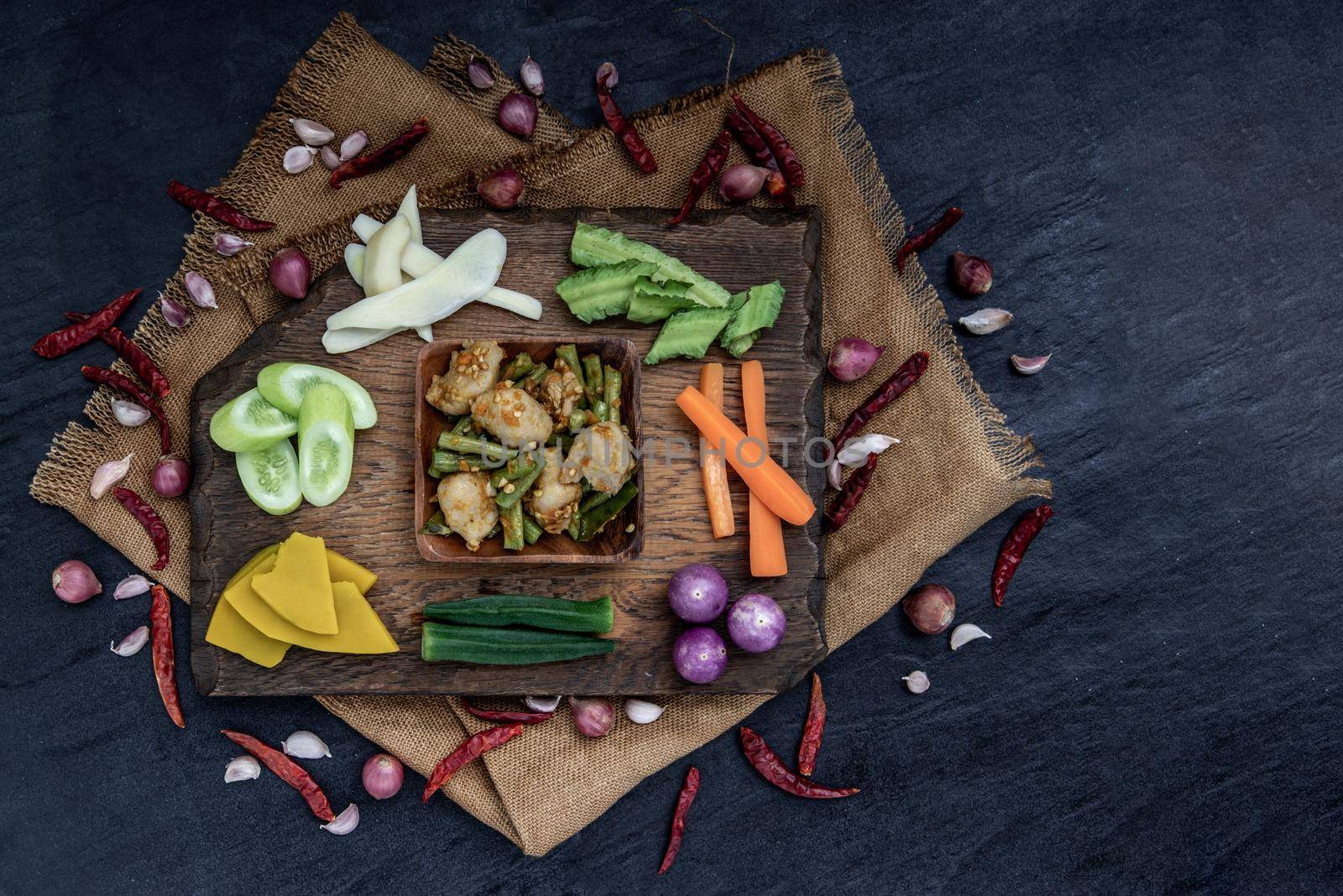 Thai food, Stir Fried fish ball with Red Curry Paste and long bean with the ingredient and fresh vegetables on wood background, view from above.