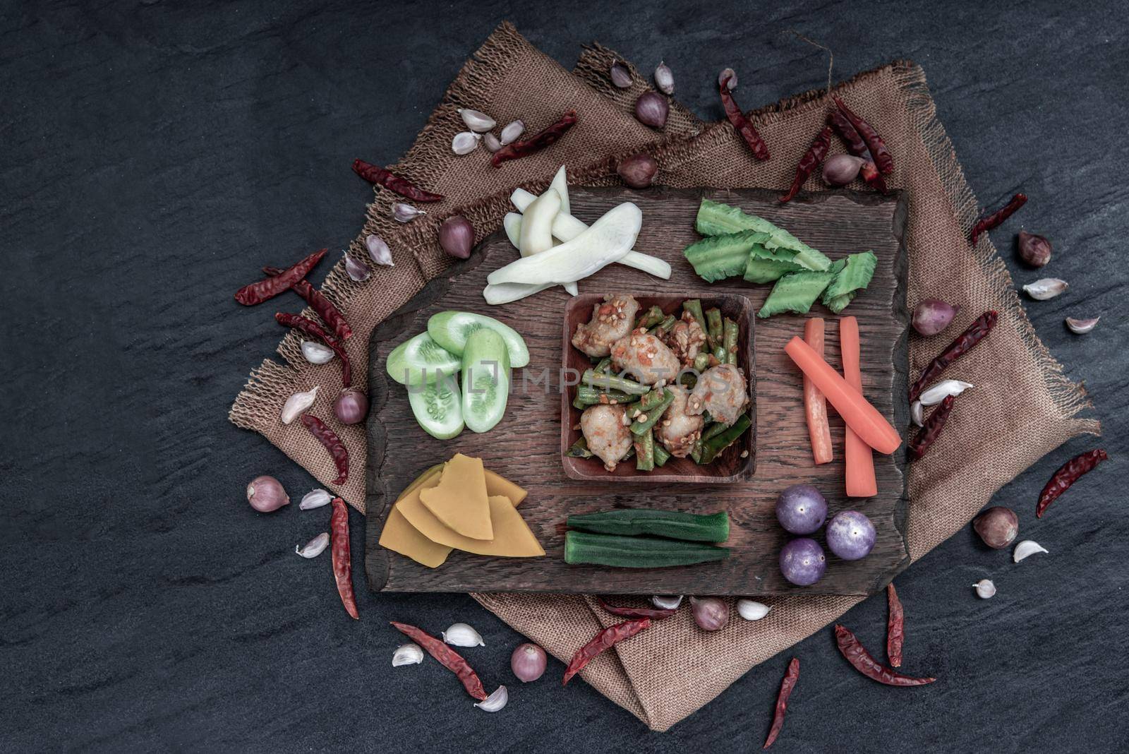 Thai food, Stir Fried fish ball with Red Curry Paste and long bean with the ingredient and fresh vegetables on wood background, view from above.