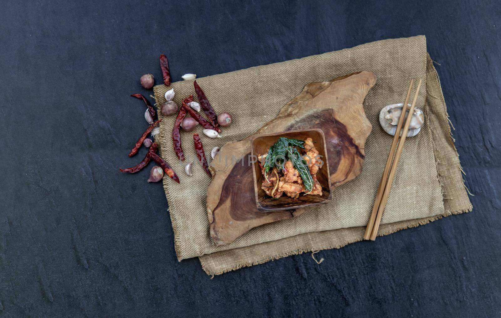 Thai Spicy food, Spicy Stir Fried Deep Fish Fillet with Herbs vegetables  in wooden bowl : in Thai language called "Pad Cha ". Top view. copy space, Selective focus.