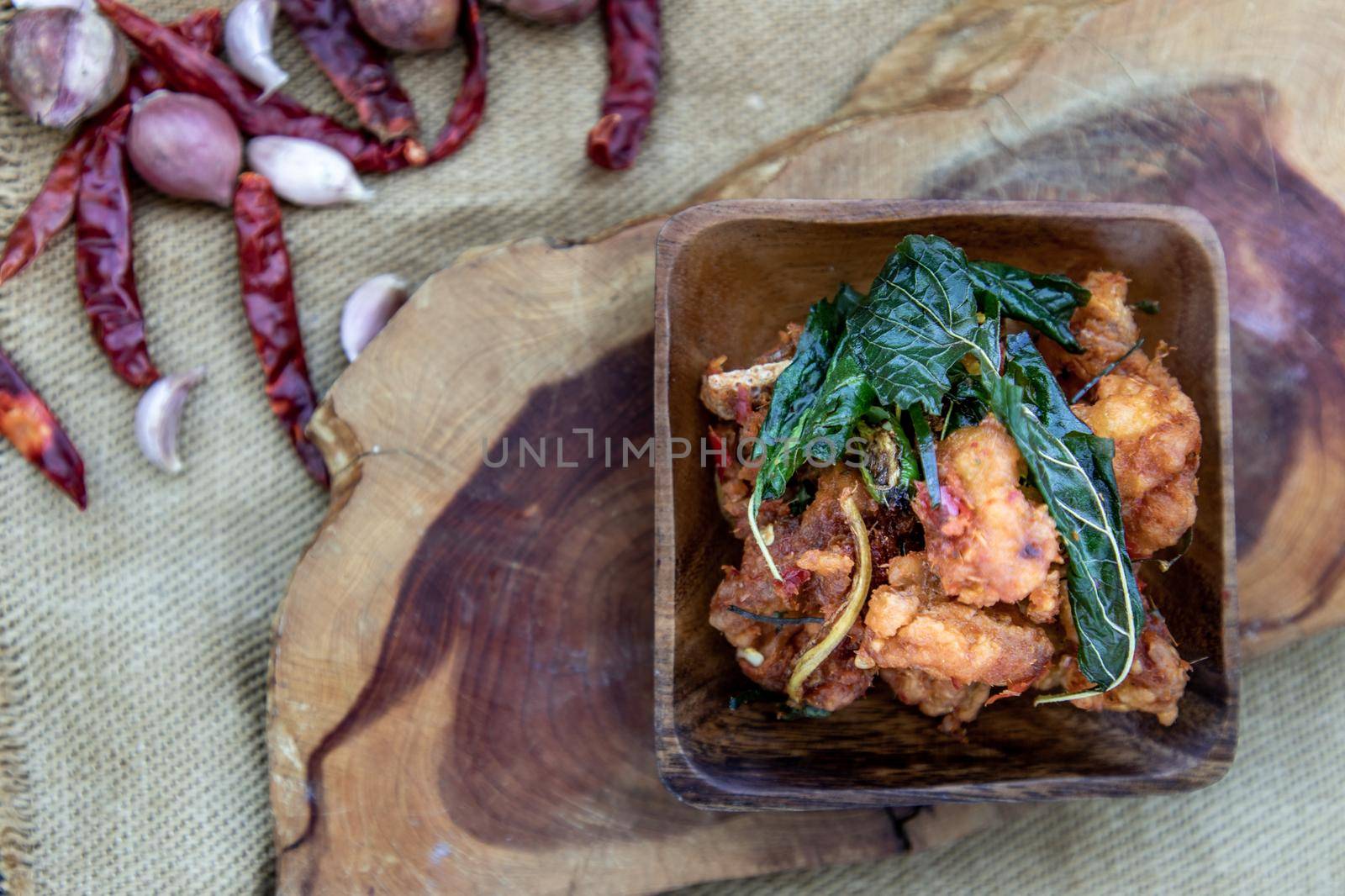Thai Spicy food, Spicy Stir Fried Deep Fish Fillet with Herbs vegetables  in wooden bowl : in Thai language called "Pad Cha ". Top view, Selective focus.