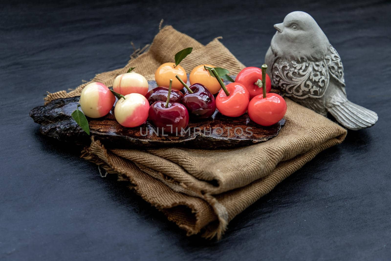 Kanom Look Choup : An old traditional thai dessert made from green been, coconut milk, sugar and jelly, Deletable imitation fruits made from green been, coconut milk, sugar and jelly in fruit shape on wooden, It is a unique dessert of Thailand, Oblique view from the top.