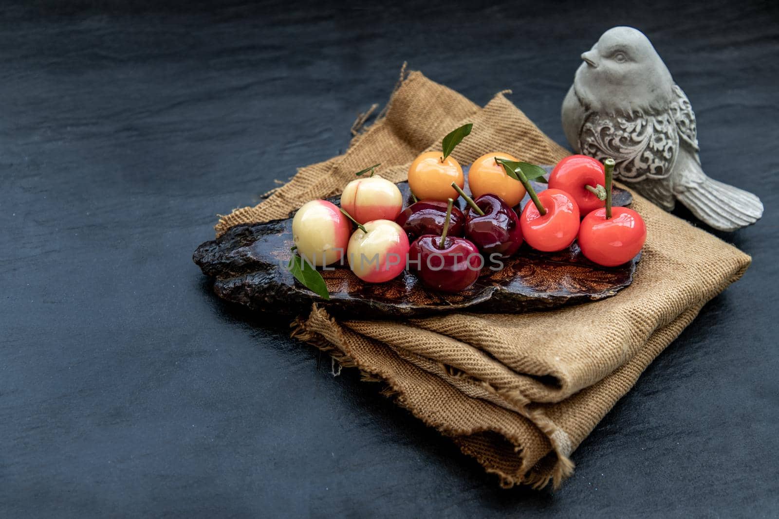 Kanom Look Choup : An old traditional thai dessert made from green been, coconut milk, sugar and jelly, Deletable imitation fruits made from green been, coconut milk, sugar and jelly in fruit shape on wooden, It is a unique dessert of Thailand, Oblique view from the top.