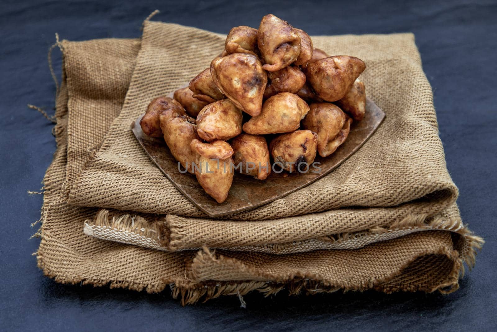 Pansib pastry stuffed on burlap fabric background, Thai style dumplings stuffed, thai dessert, kind of snack, Oblique view from the top, Selective focus.