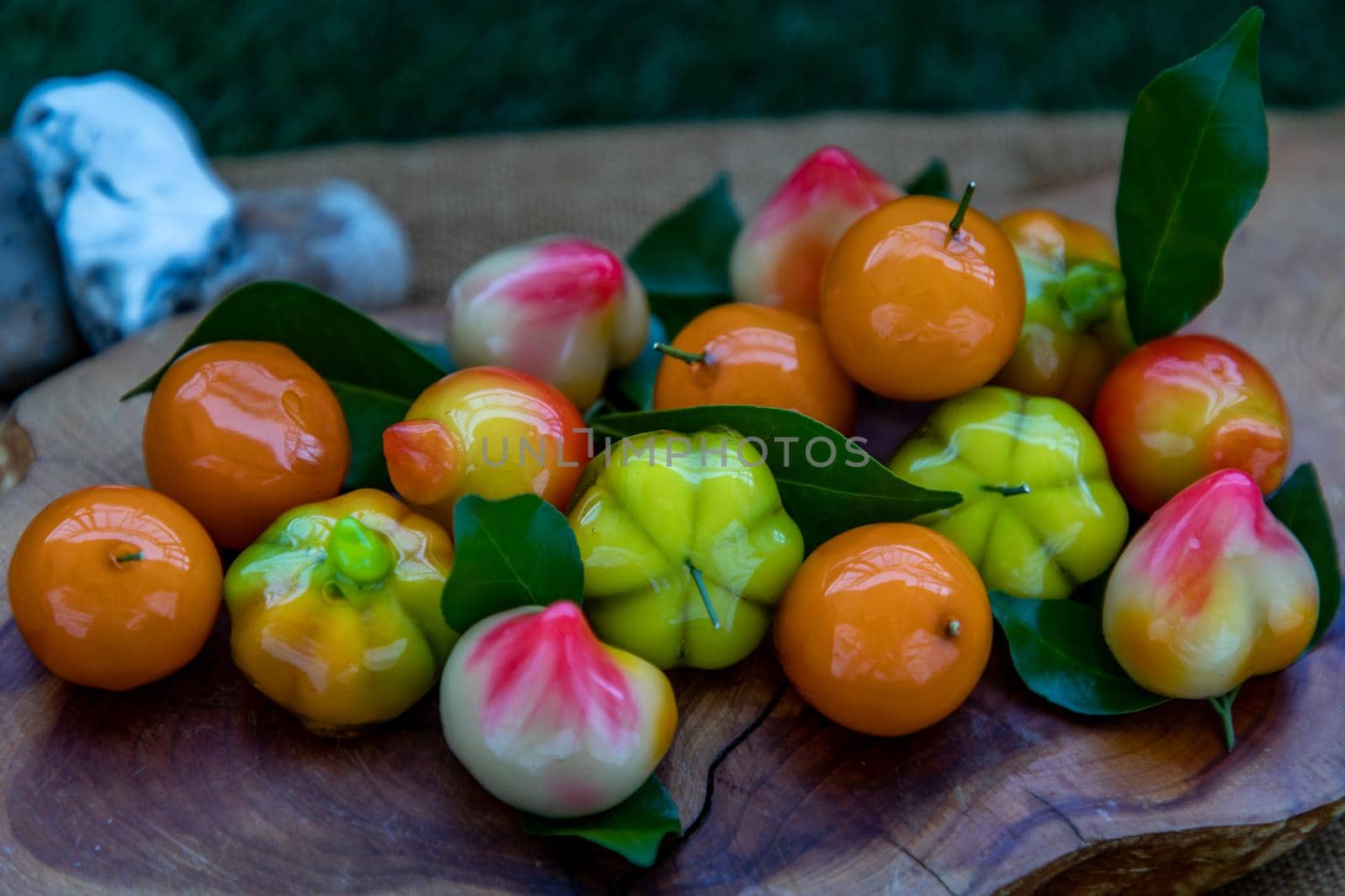 Close up of Kanom Look Choup : An old traditional thai dessert made from green been, coconut milk, sugar and jelly, Deletable imitation fruits made from green been, coconut milk, sugar and jelly in fruit shape on wooden, It is a unique dessert of Thailand.