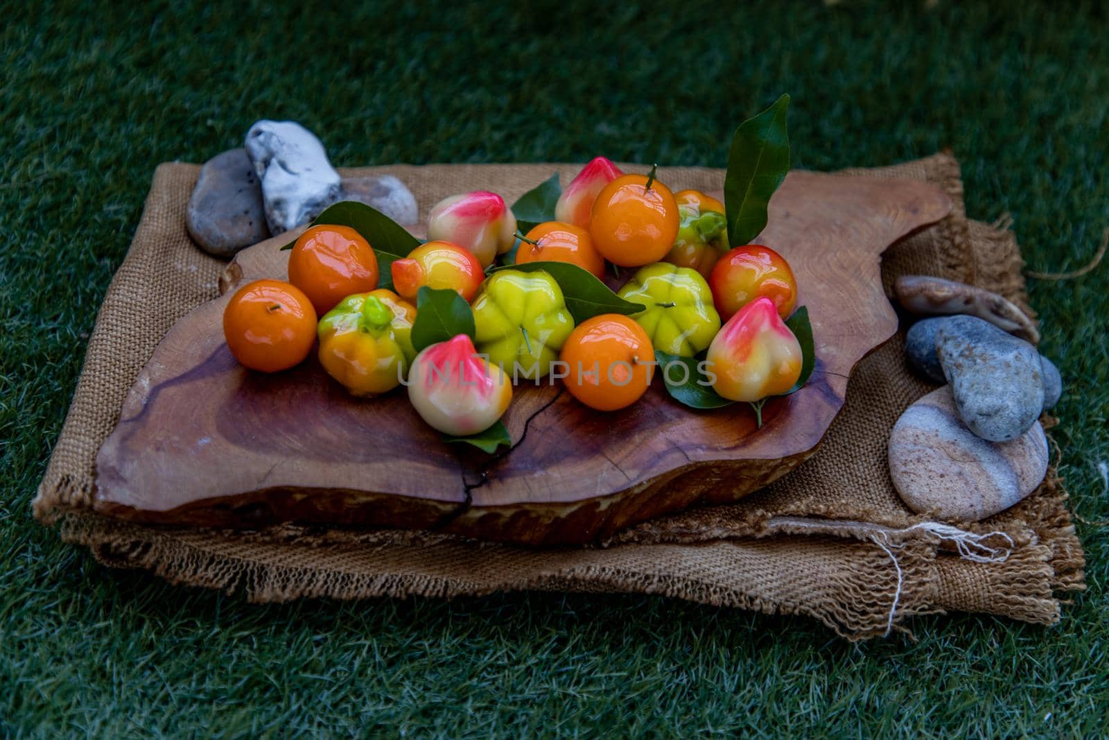 Kanom Look Choup : An old traditional thai dessert made from green been, coconut milk, sugar and jelly, Deletable imitation fruits made from green been, coconut milk, sugar and jelly in fruit shape on wooden, It is a unique dessert of Thailand, Oblique view from the top.