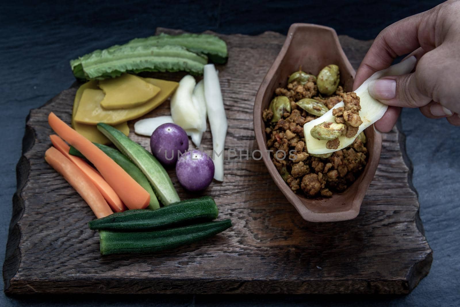 Thai food, The hand is using ginger to scoop Southern Thai dry curry with ground pork Khua Kling, Thai dry curry with ground pork with Herbs vegetables.