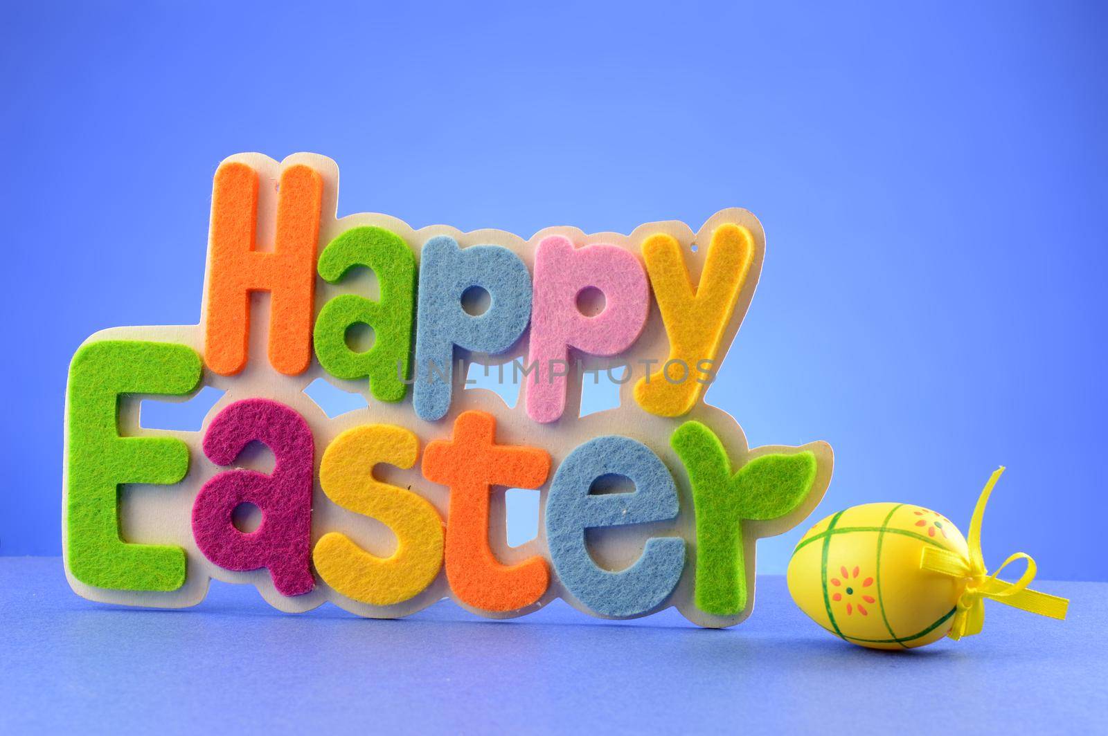 A festive sign for the holiday season that says Happy Easter over a blue background.