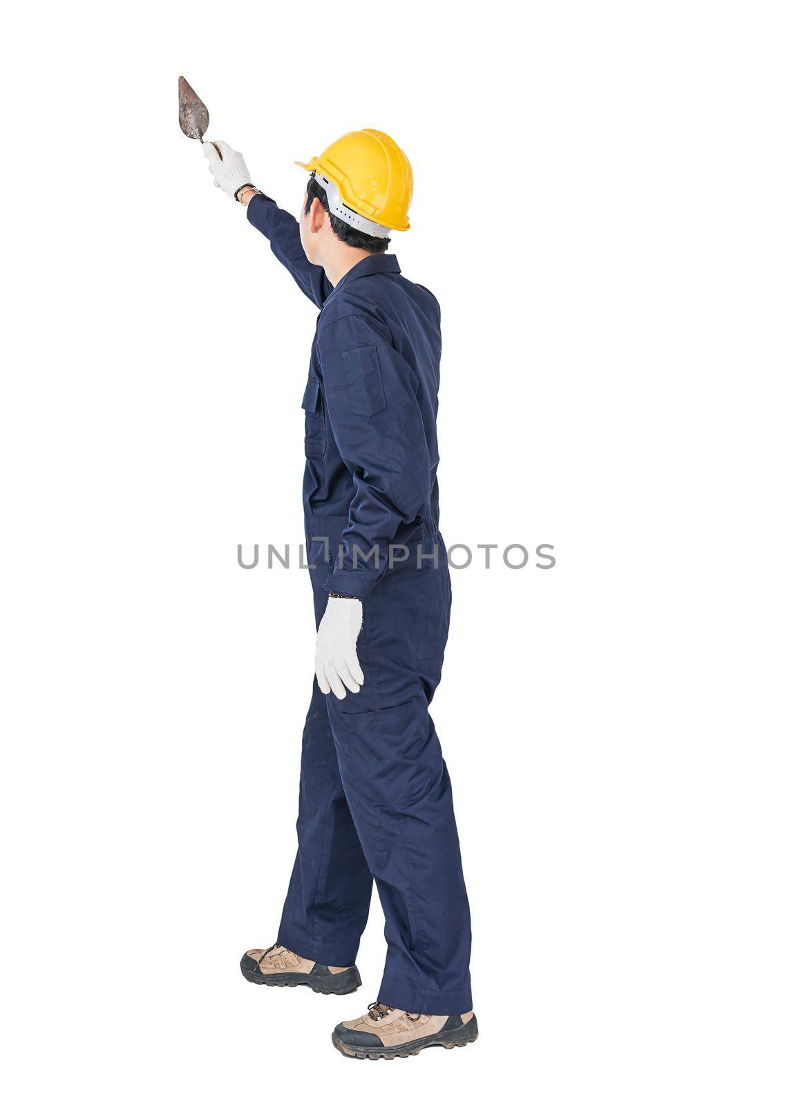 Workman with blue coveralls and hardhat in a uniform holding steel trowel by stoonn