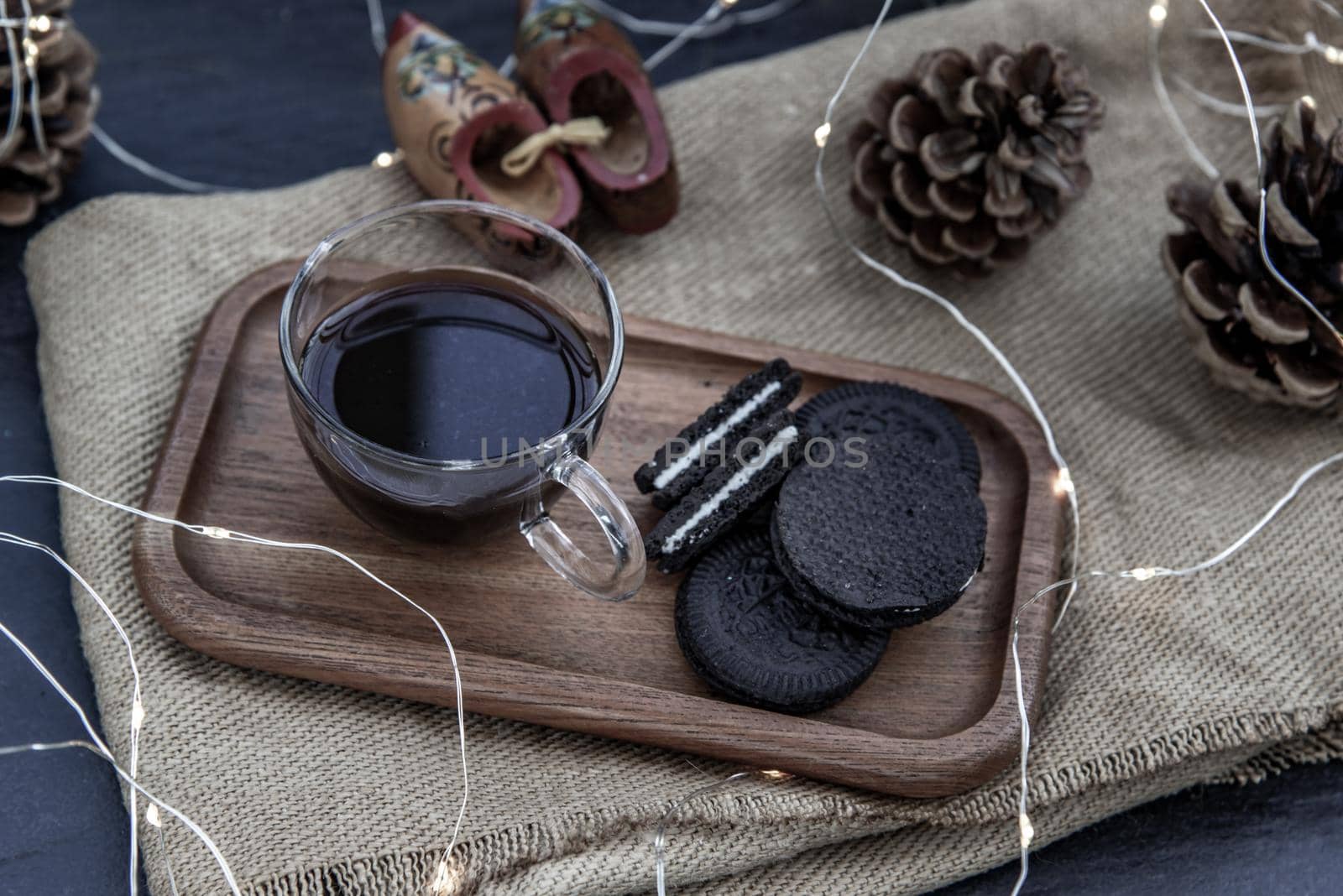 Cup of coffee with chocolate chip cookies on wooden tray. Concept for a tasty snack, Selective focus, Oblique view from the top.