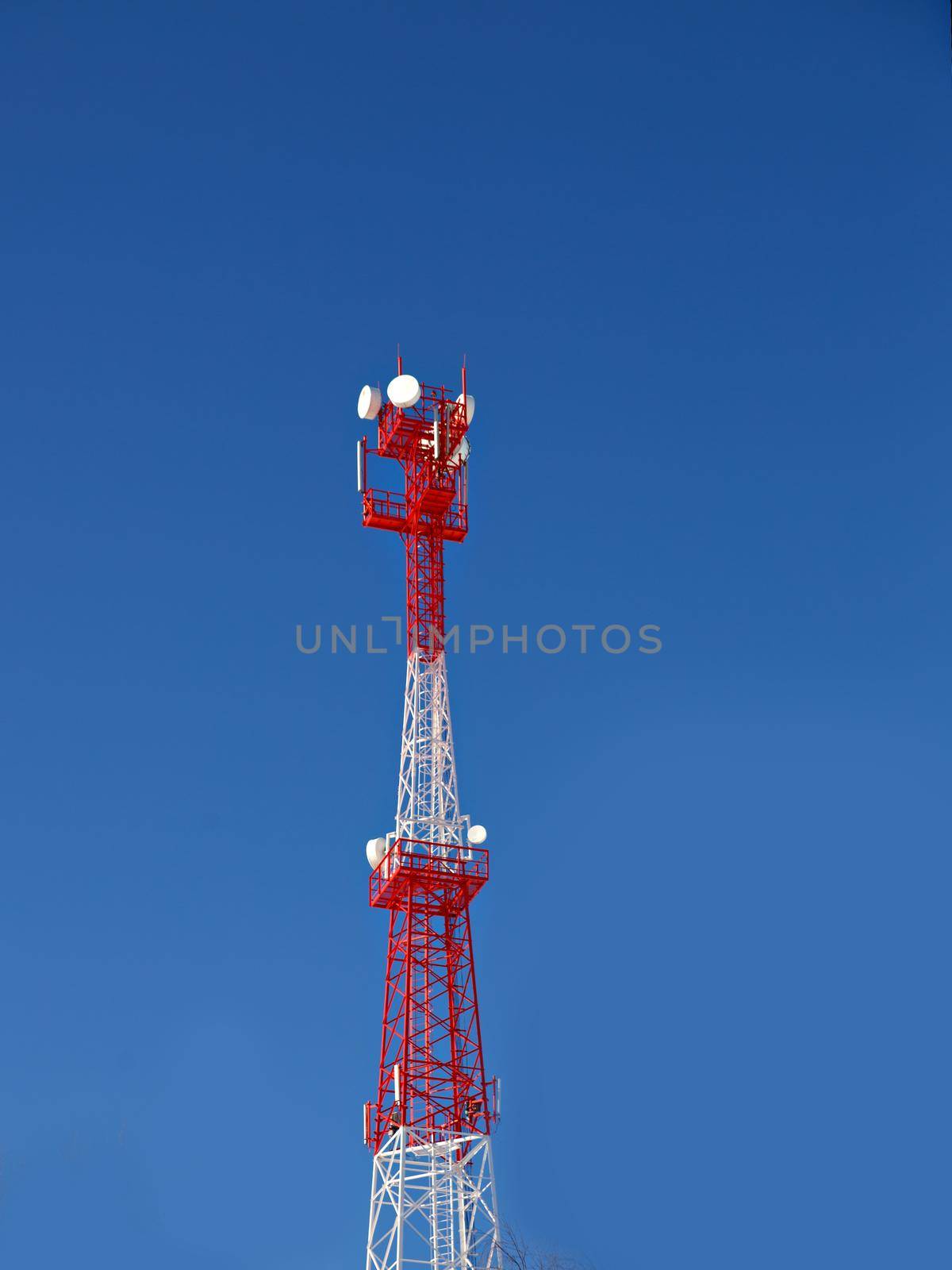 Cellular base station against blue sky on sunny day.