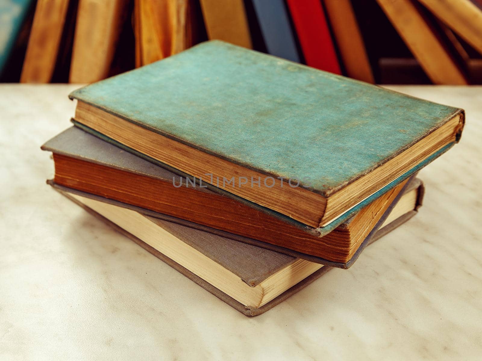 Three old books lie on light table by Sestra