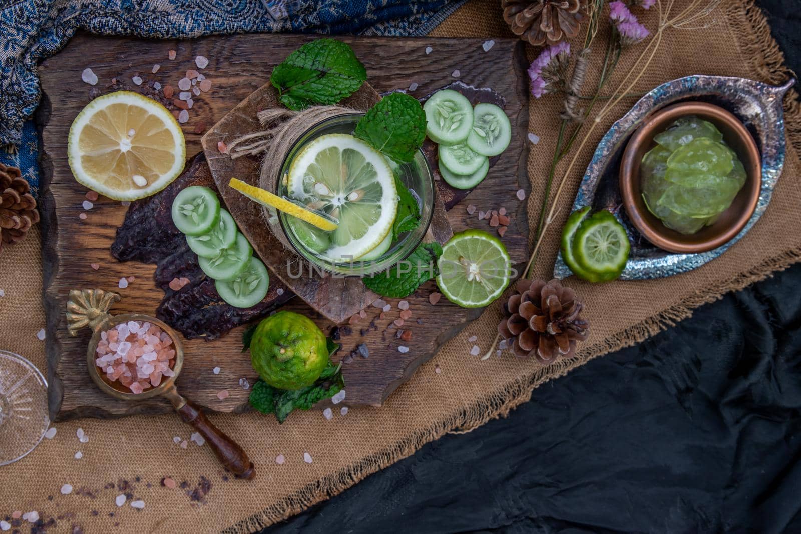 Cold water with lemon, kaffir lime, cucumber and mint leave on wooden background. Summer time, Healthy drink, vegetable juice, healthy food concept, Selective Focus.