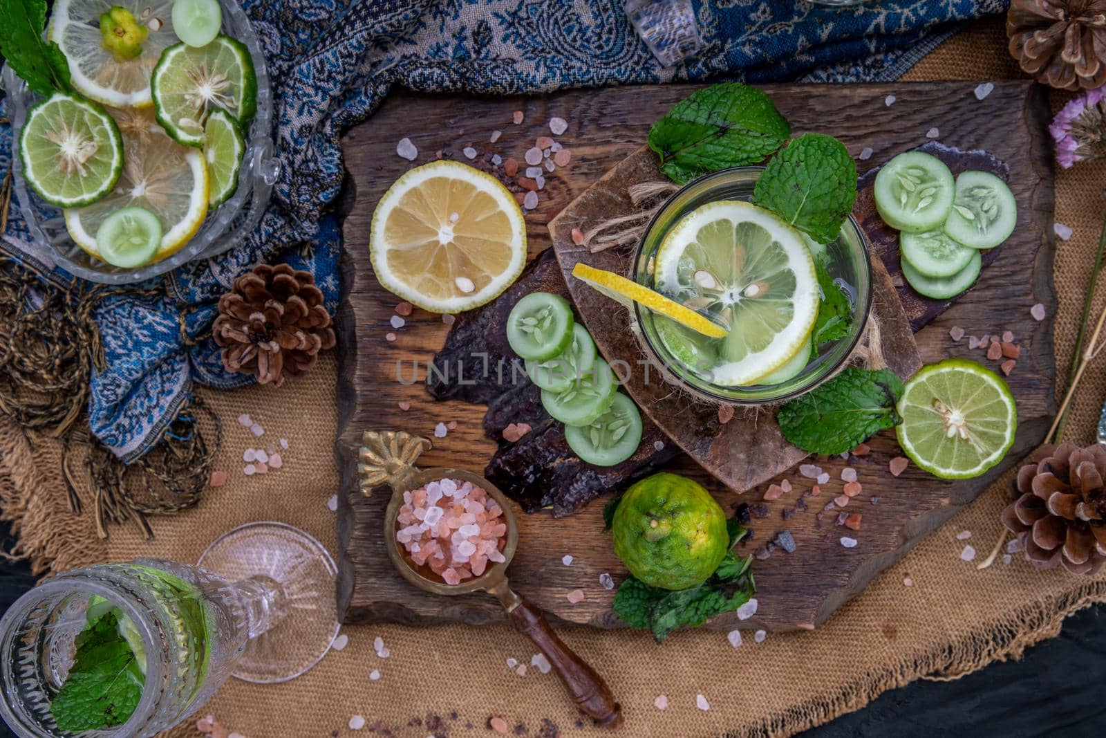 Cold water with lemon, kaffir lime, cucumber and mint leave on wooden background. Summer time, Healthy drink, vegetable juice, healthy food concept, Selective Focus.