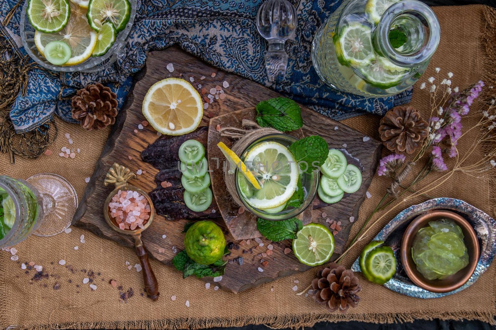 Cold water with lemon, kaffir lime, cucumber and mint leave on wooden background. Summer time, Healthy drink, vegetable juice, healthy food concept, Selective Focus.