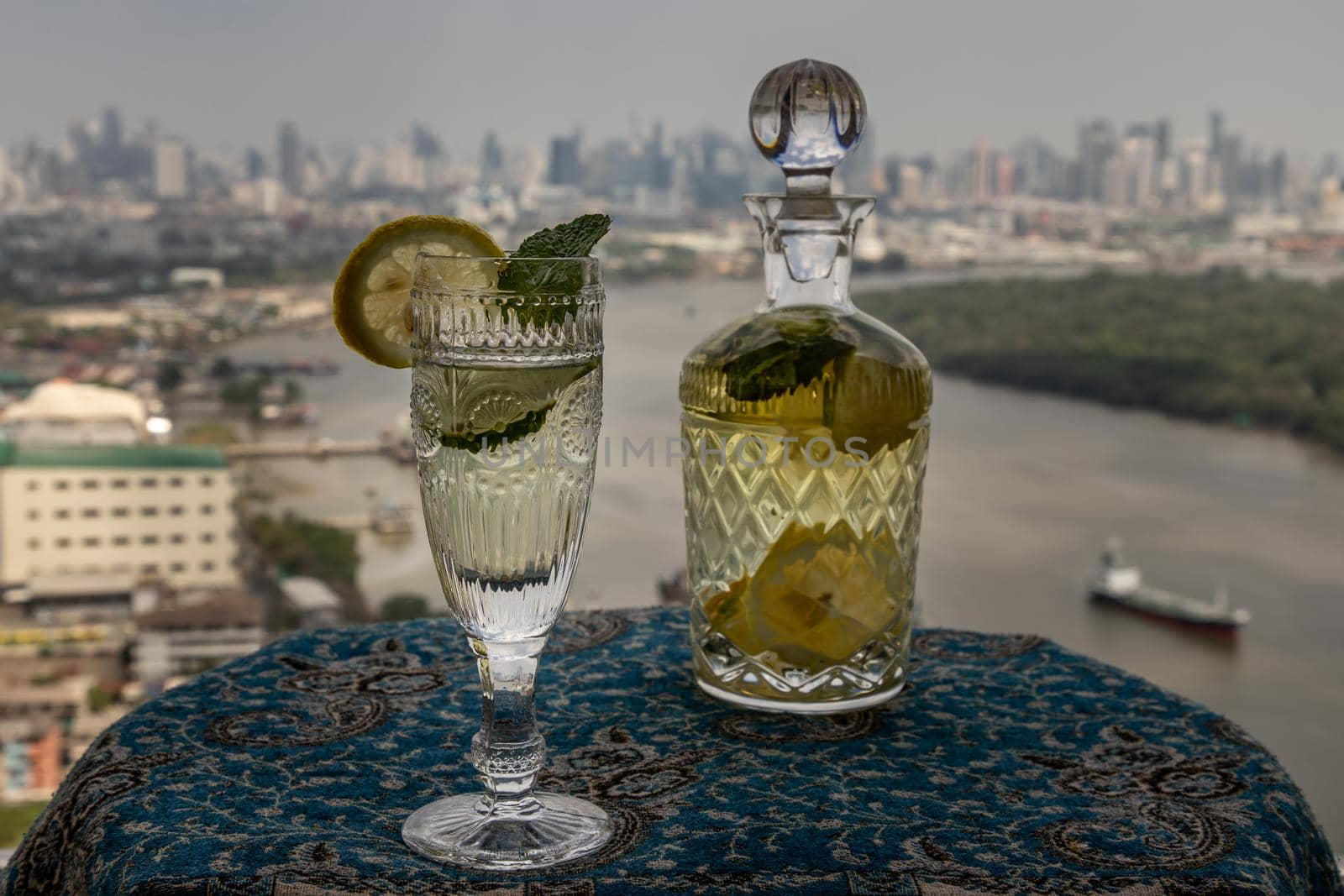 Cold water with lemon, kaffir lime, cucumber and mint leave on the table in front of sky background. Summer time, Healthy drink, vegetable juice, Selective Focus.
