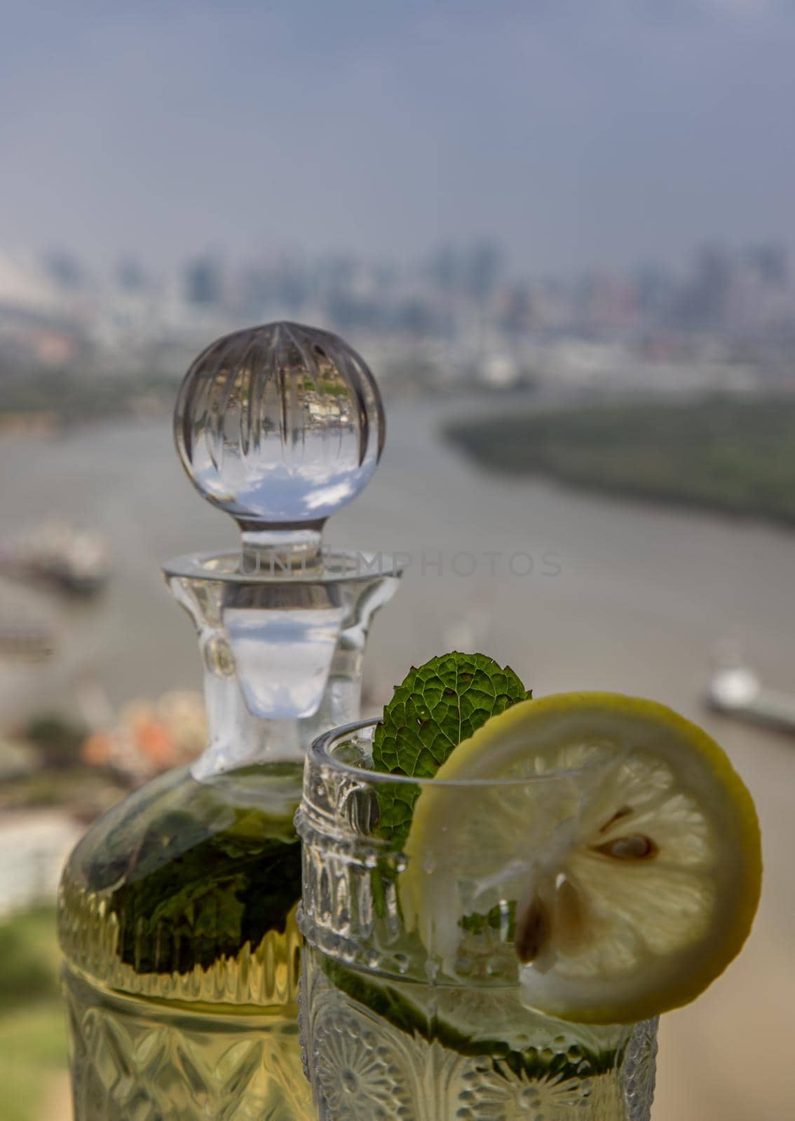Cold water with lemon, kaffir lime, cucumber and mint leave on the table in front of sky background. Summer time, Healthy drink, vegetable juice, Selective Focus.