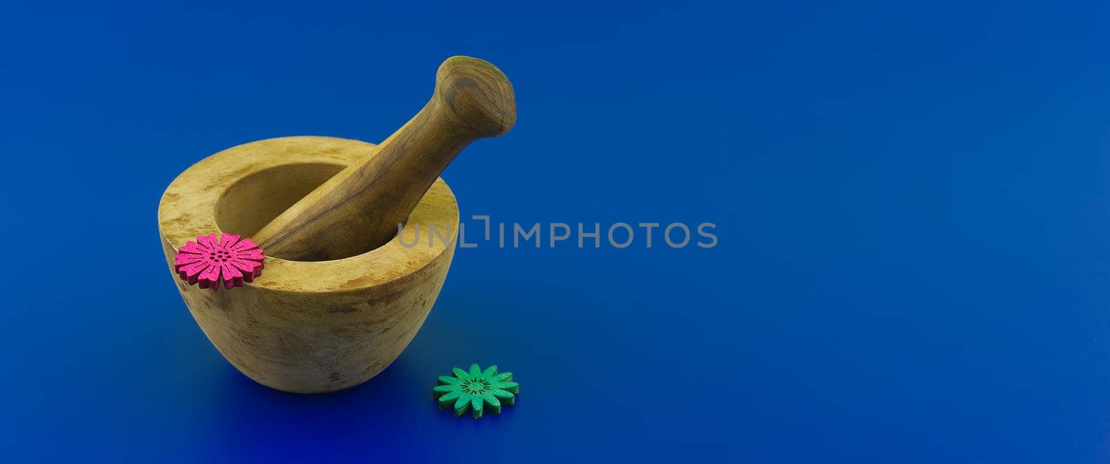 Wooden rustic style mortar and pestle. Spices and herb grinder over blue background with free space for text