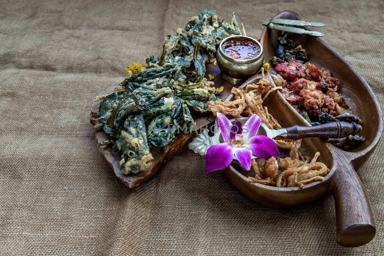 Crispy Flowers, Crispy Herbs and Crispy Vegetables served  with Sweet sauce in a Wooden tray, Oblique view from the top, copy space.