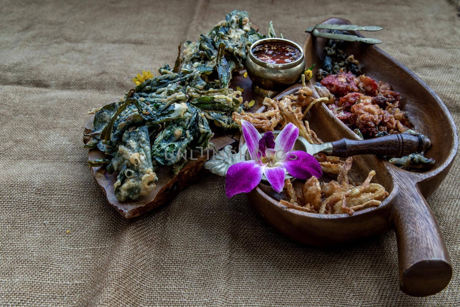 Crispy Flowers, Crispy Herbs and Crispy Vegetables served  with Sweet sauce in a Wooden tray, Oblique view from the top, copy space.