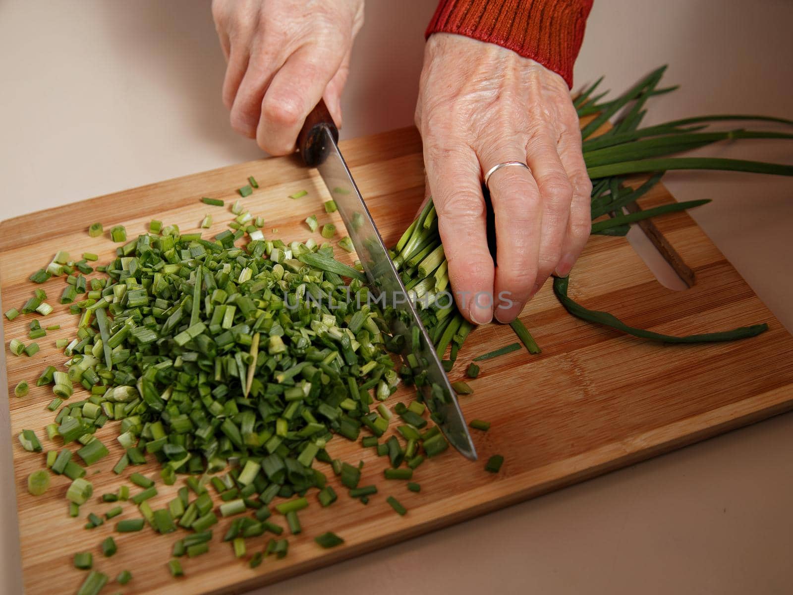 Green onion feathers cut into salad with sharp knife by Sestra