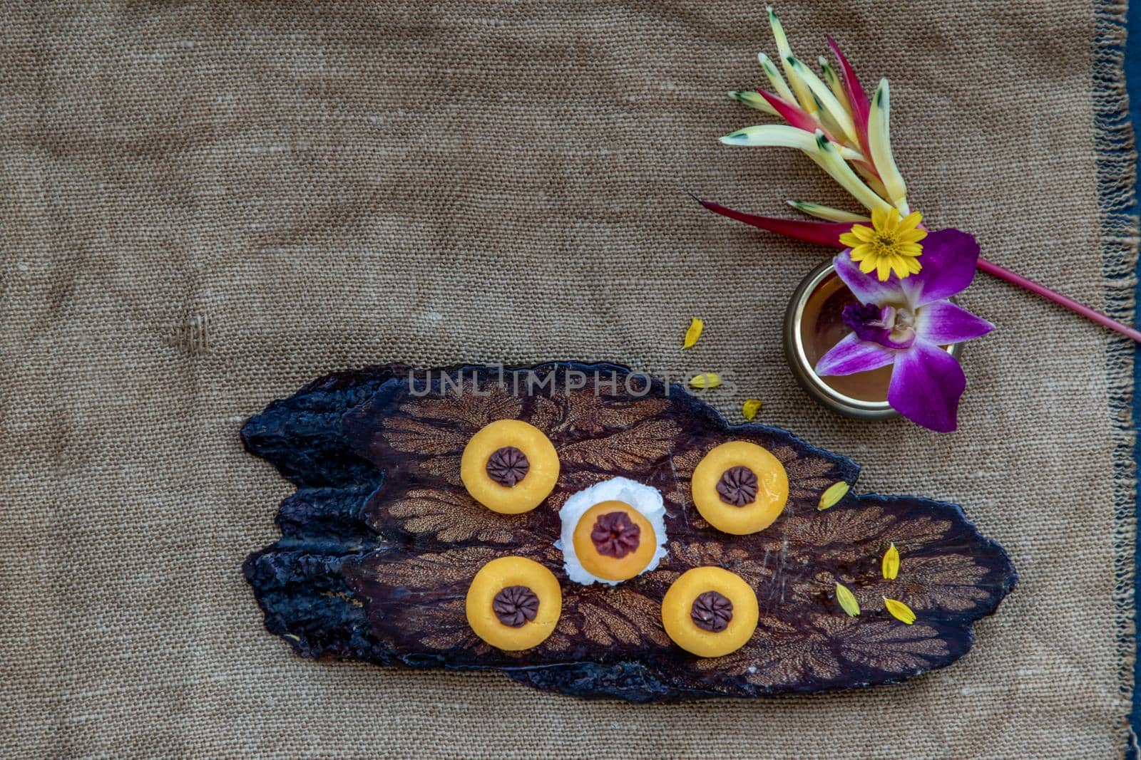 Traditional Thai Dessert (Kanom Thai) : Sanay Chan Made from minced coconut mixed with flour, sugar, egg yolk, rice flour and chan herb serving in a dark wooden, Top view.