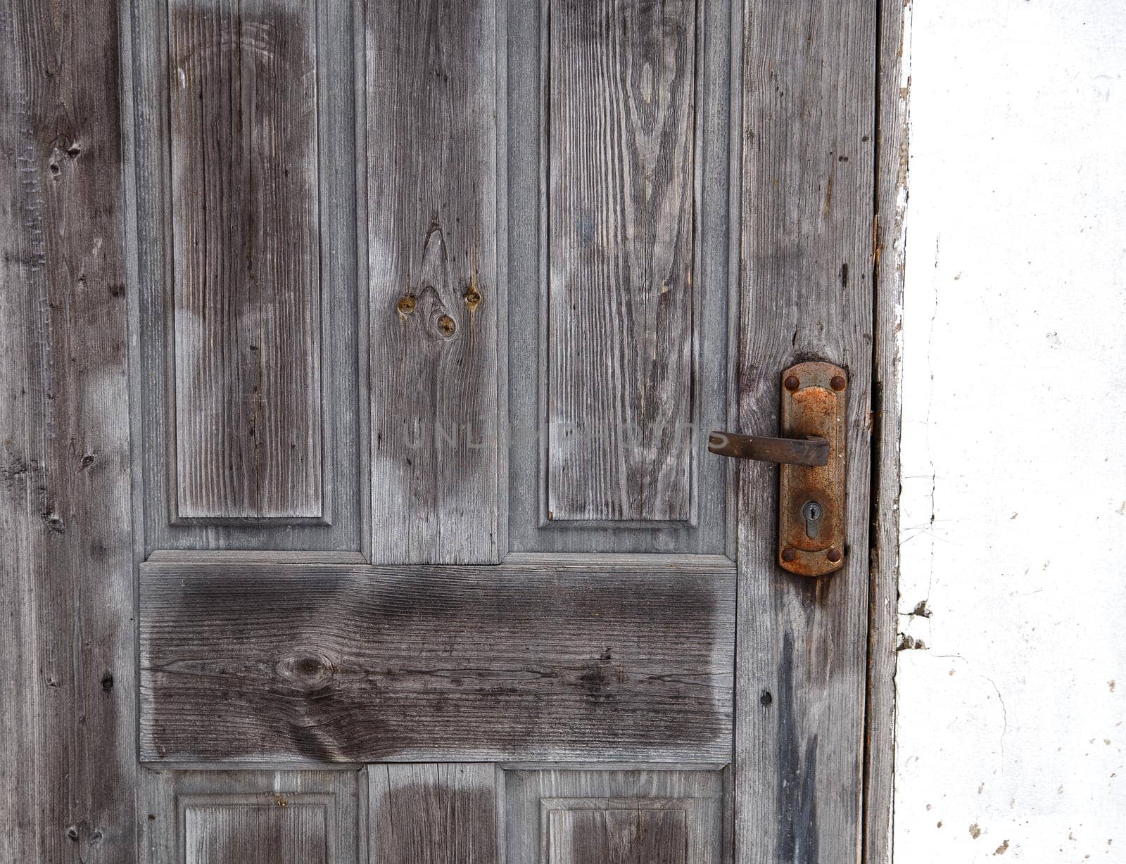 Wooden door with linings and rusty lock.