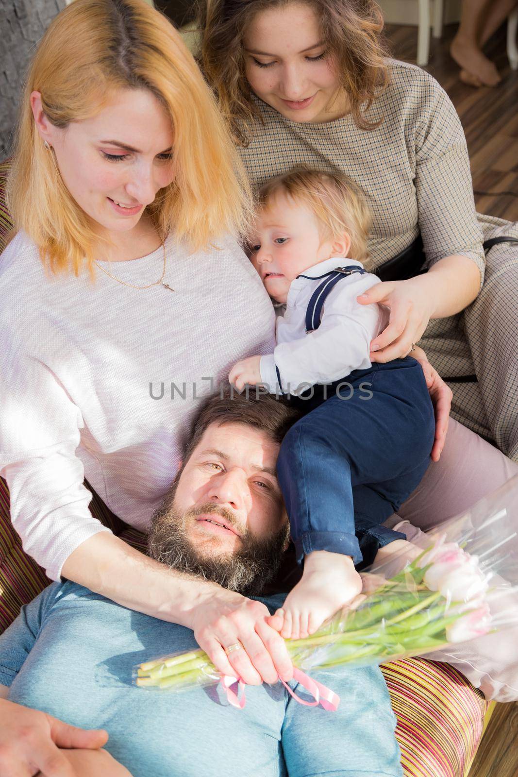Dad with children congratulate mom on the holiday, mother's day. Have fun, laugh and give flowers