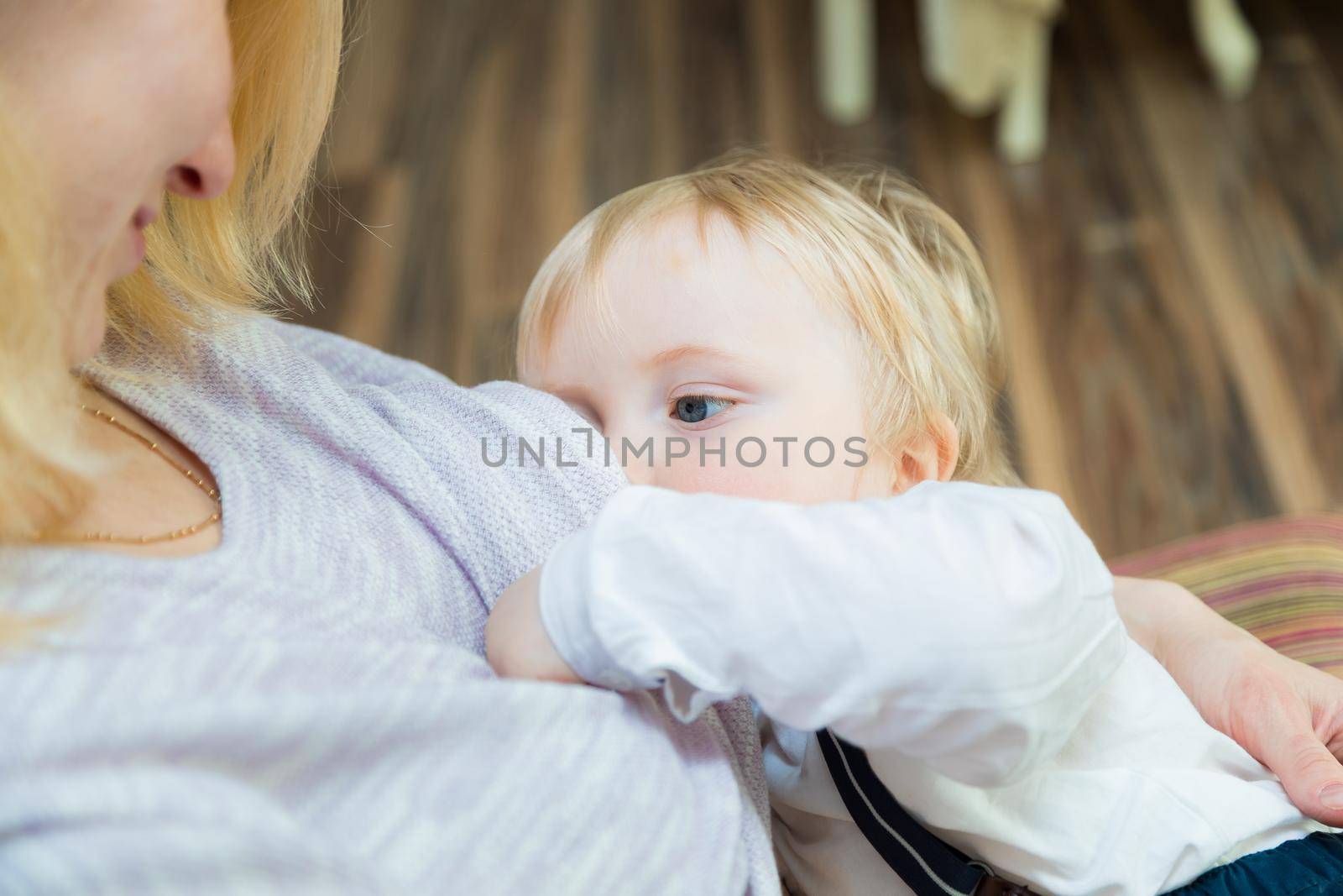 Mom is breastfeeding the baby. She looks at the baby with love and tenderness. Close-up
