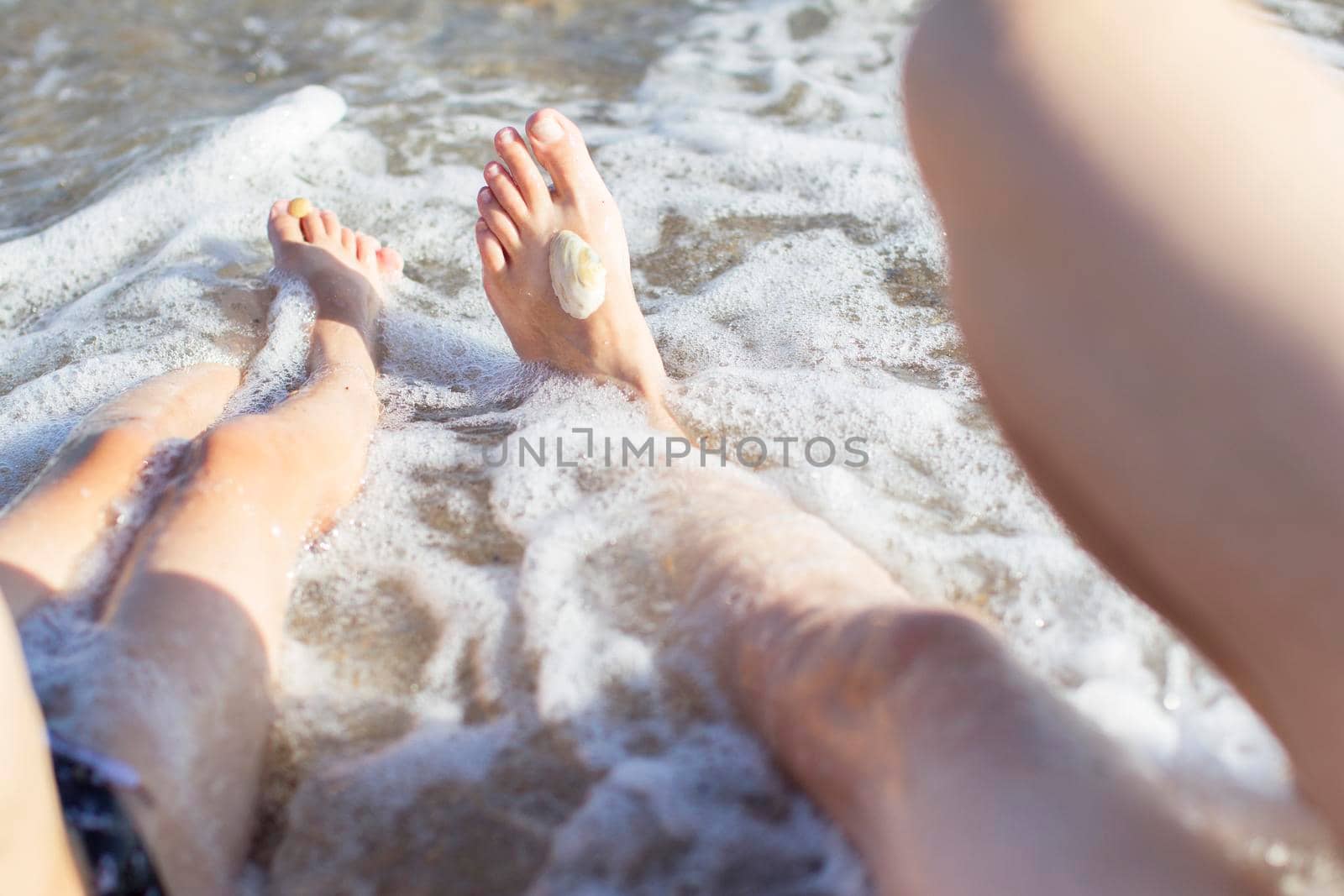 Feet of mom and baby in sea water