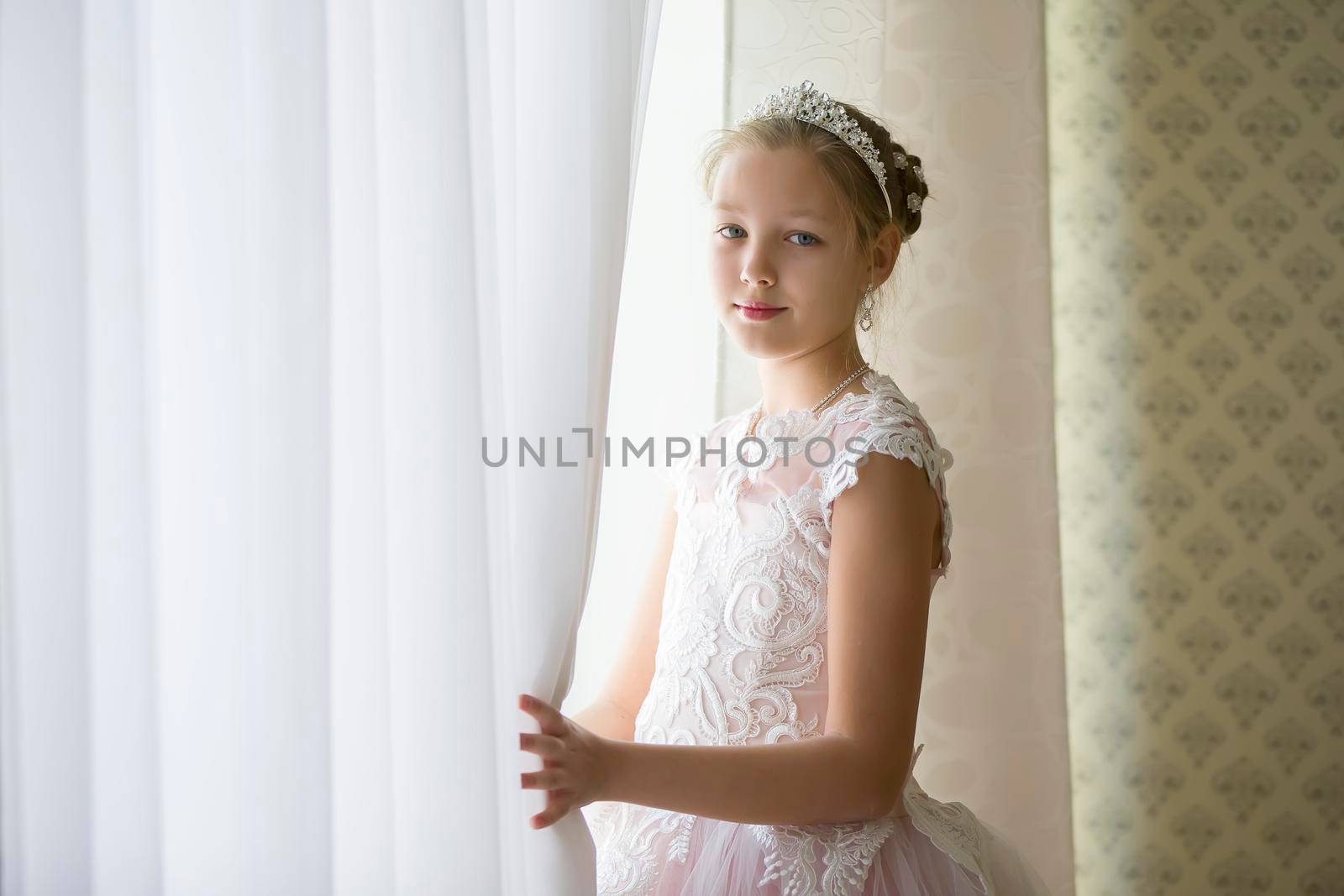 Beautiful girl in a crown near the window opened the curtain by Sviatlana