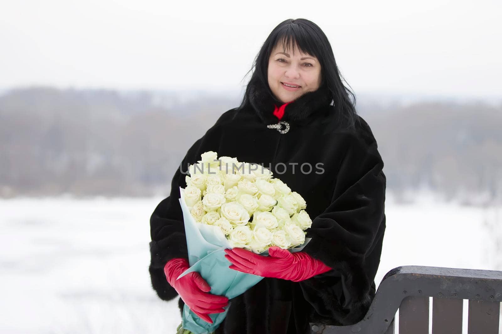 Luxurious elderly woman with a huge bouquet of flowers of roses on the street by Sviatlana