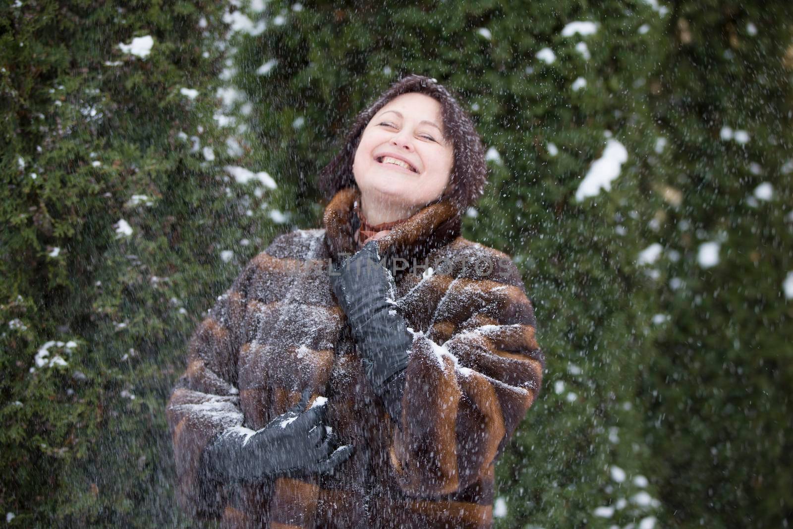 Woman in a fur coat covered with snow