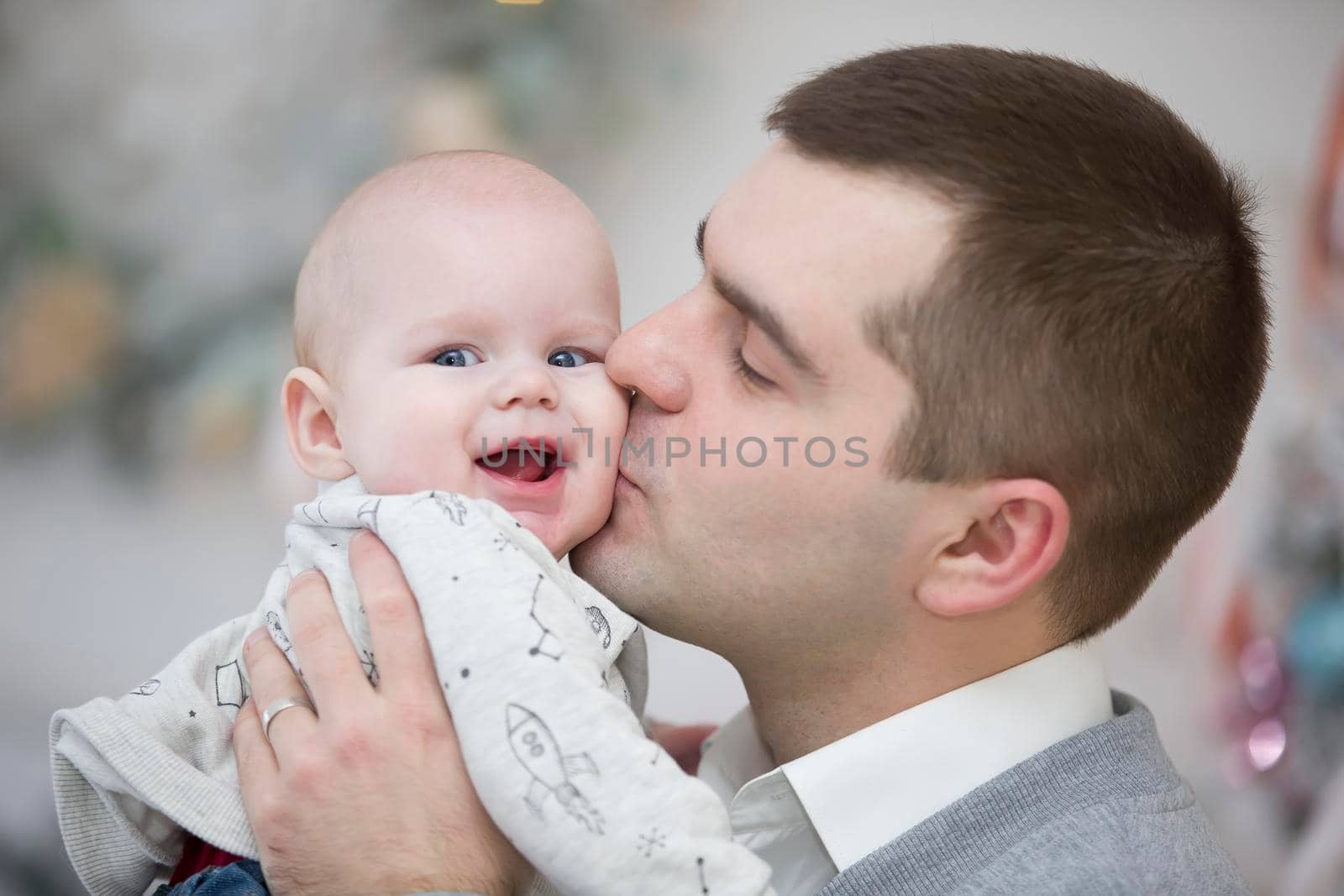 Dad kisses a happy baby