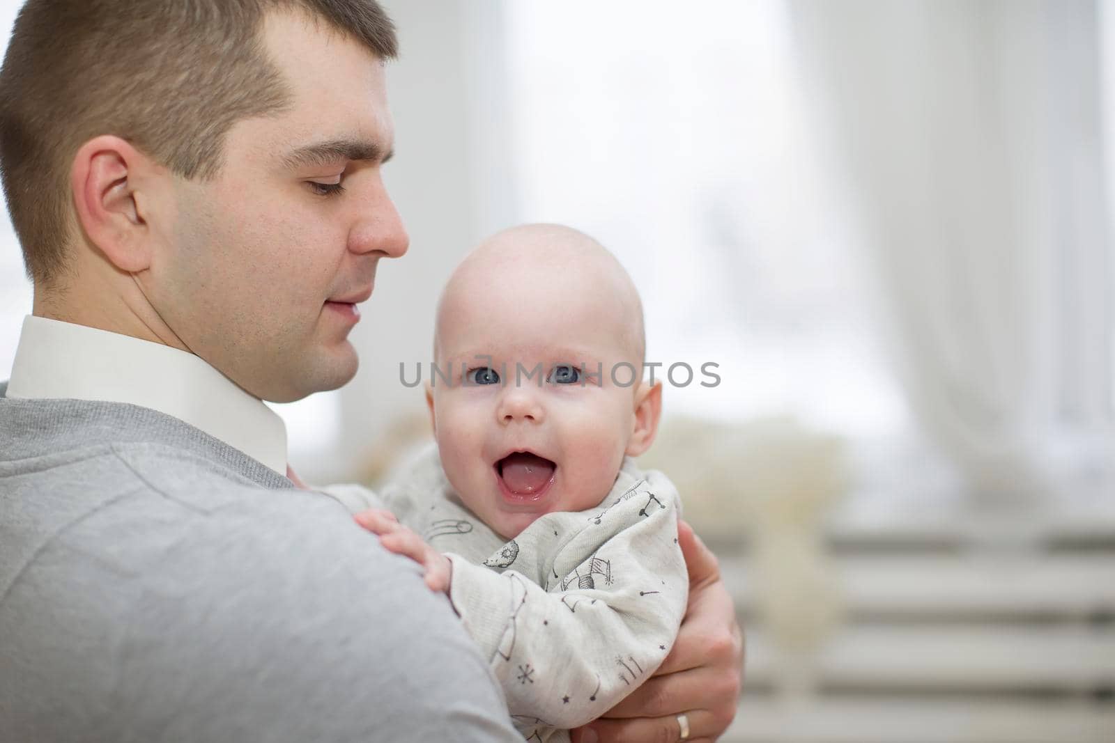Father holds baby.Cheerful baby in the arms of the parent
