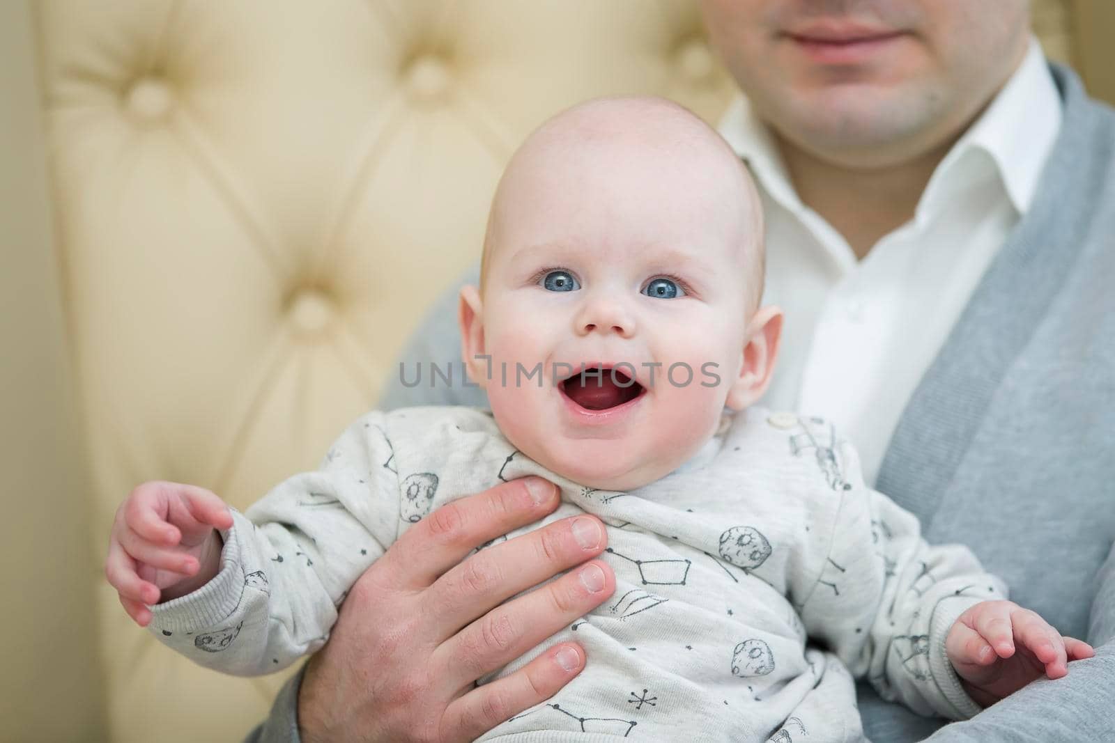 Cheerful playful baby in his father's arms. Baby and dad