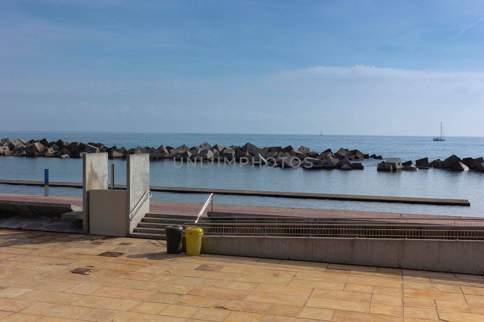 Saltwater pool in the Mediterranean Sea, in winter, without waves and a cloudy blue sky. November in Barcelona Spain.