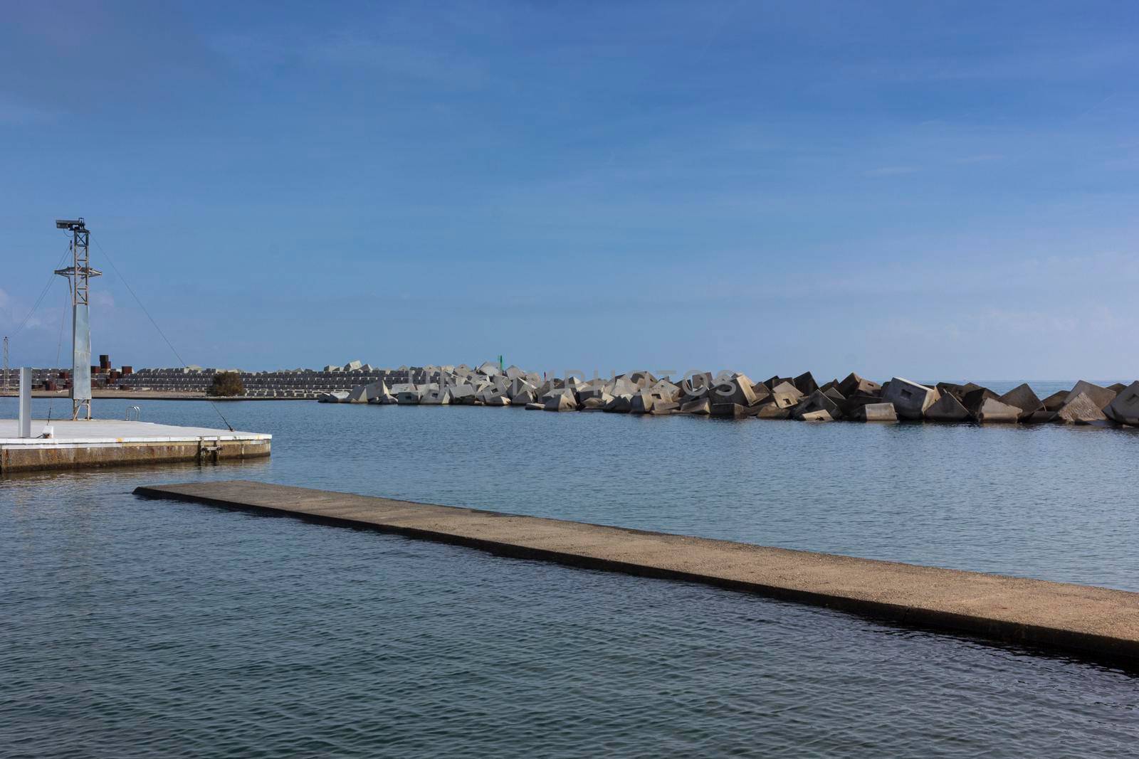 Saltwater pool in the Mediterranean Sea, in winter, without waves and a cloudy blue sky. November in Barcelona Spain.