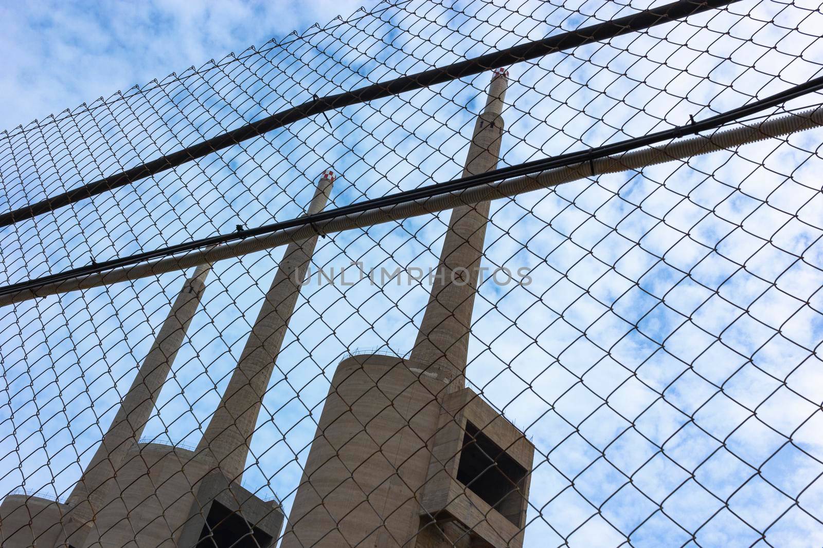 Old disused thermal power plant for the production of electricity in Barcelona behind a metal fence in Barcelona Spain