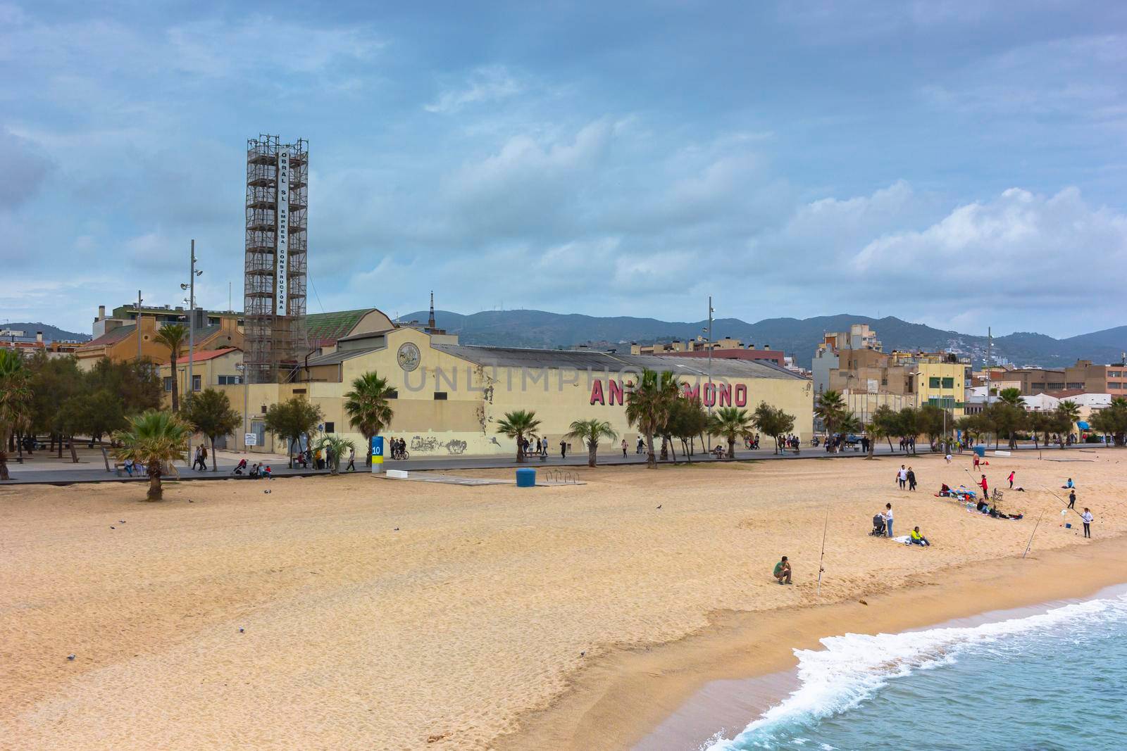 Barcelona beach in winter, with a calm sea and a cloudy blue sky