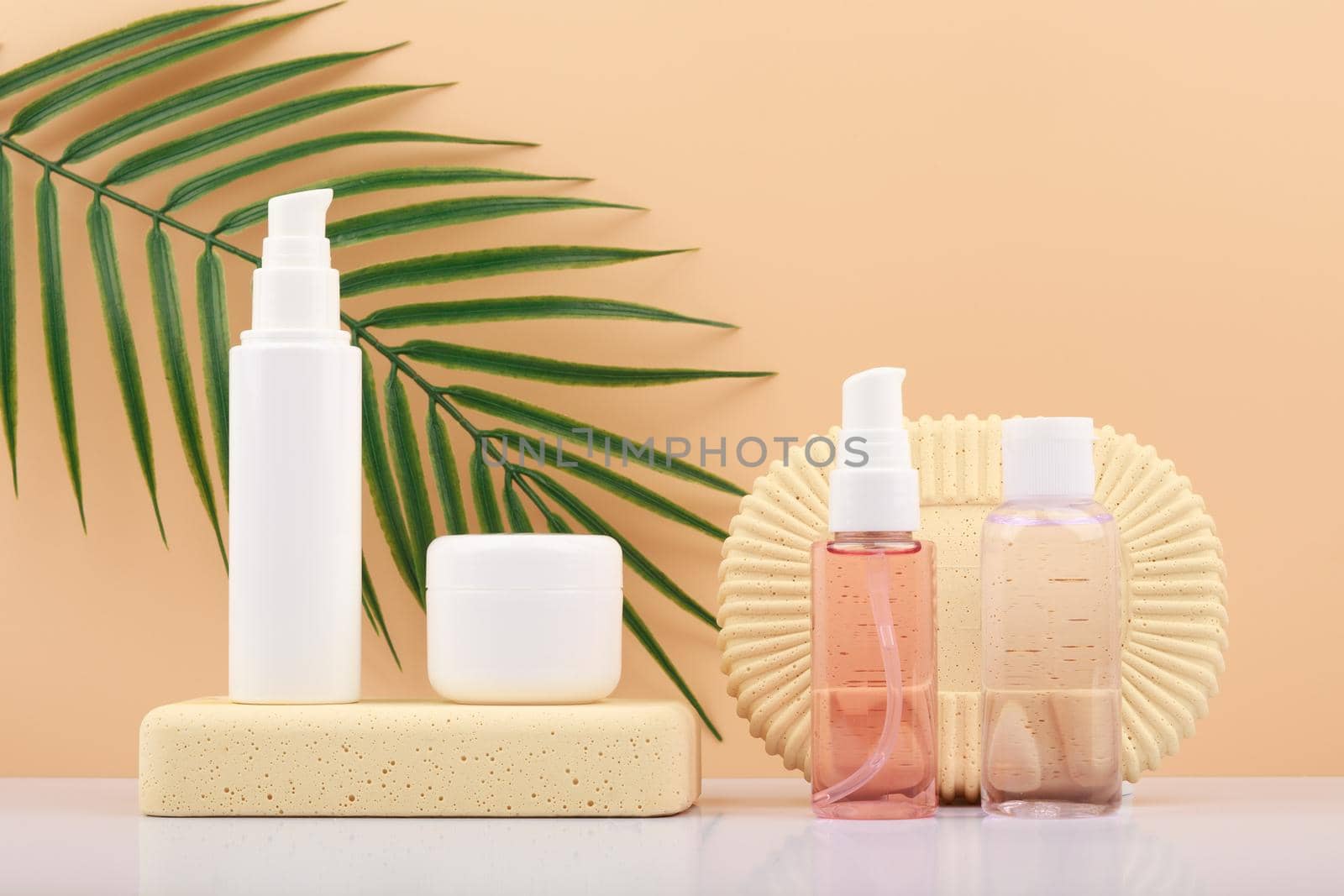 Cosmetic set with mask, cream and lotion against beige background with palm leaf. Concept of organic beauty products by Senorina_Irina