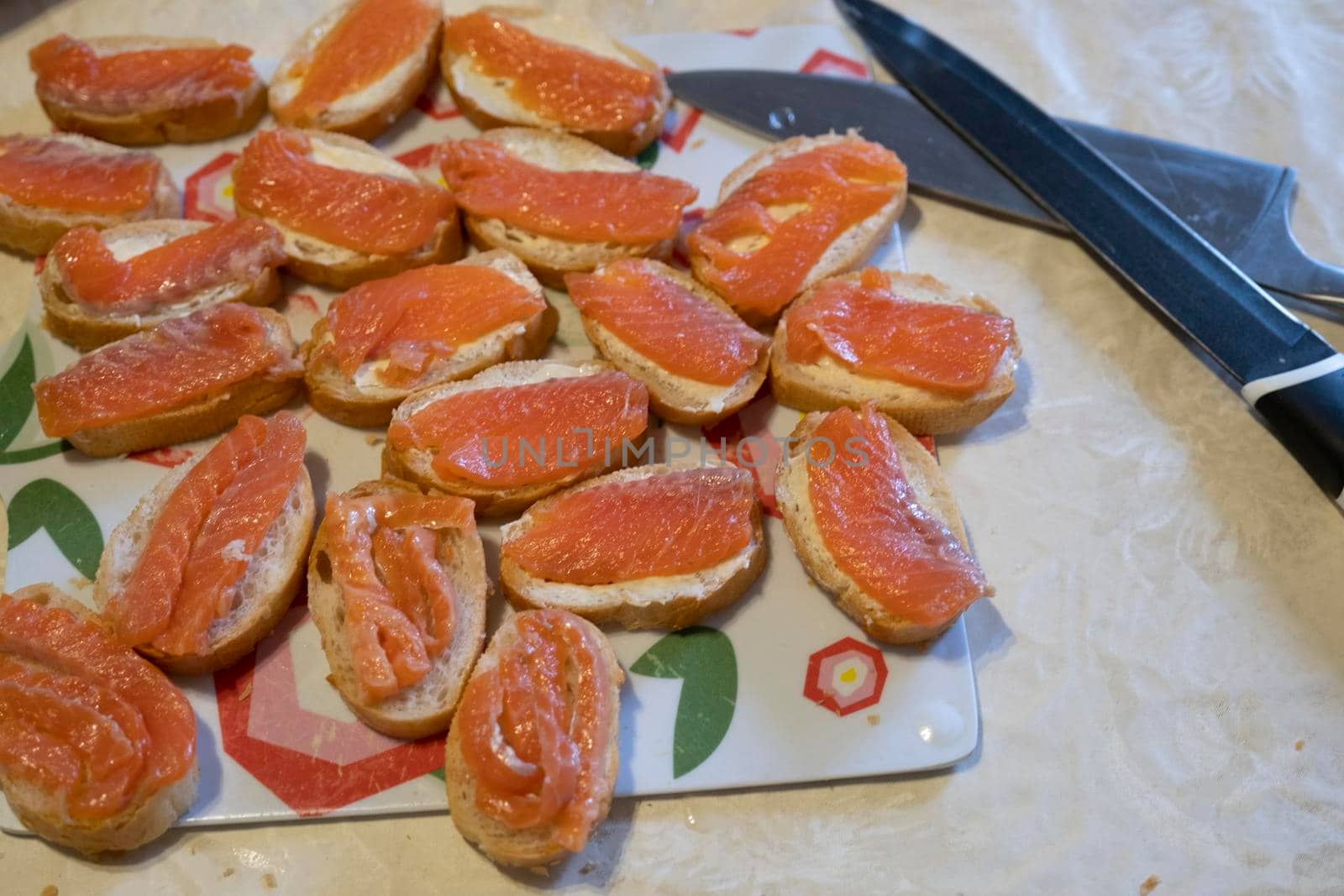 A woman lays out sandwiches with the fish on the plate. Cooking, fish dishes, healthy and diet food.