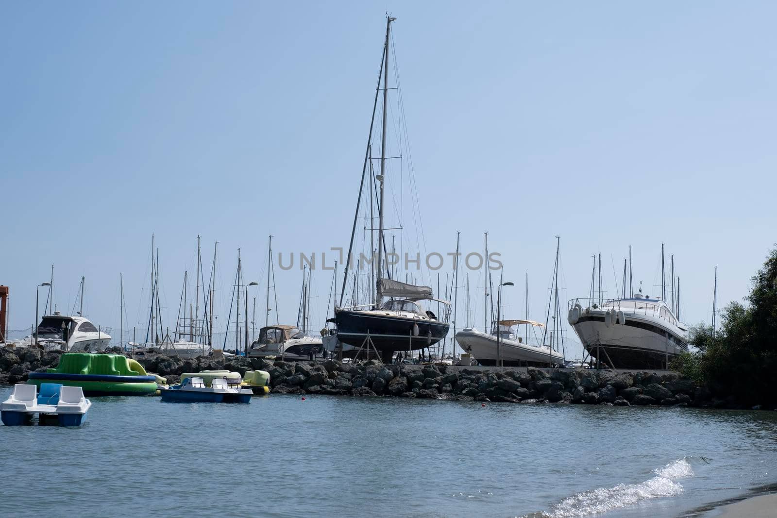 Large sailing boats and yachts on the pier on a clear Sunny day.