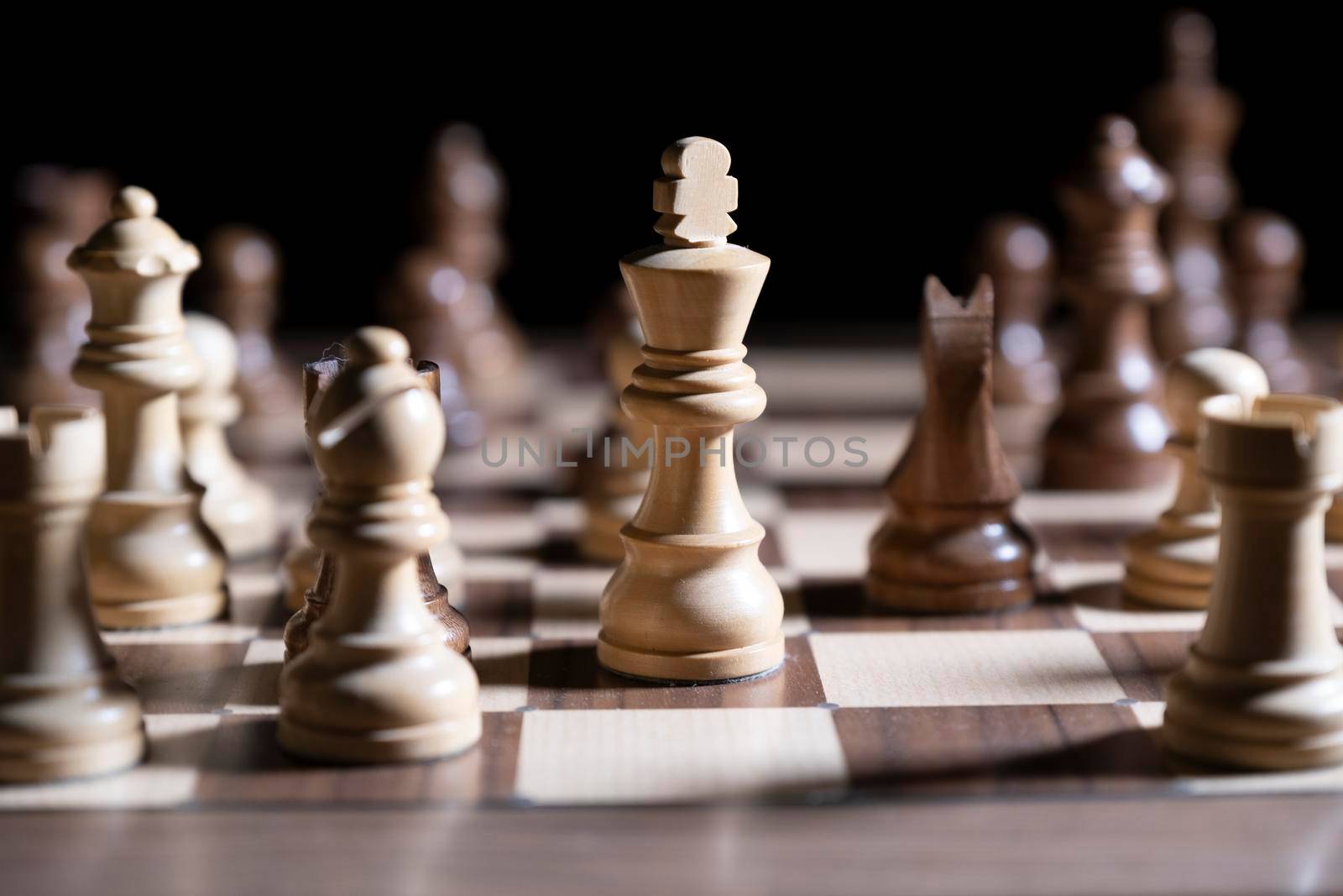 Chess game. White and black pieces are fighting for victory. The Central figure is in focus. by designprojects