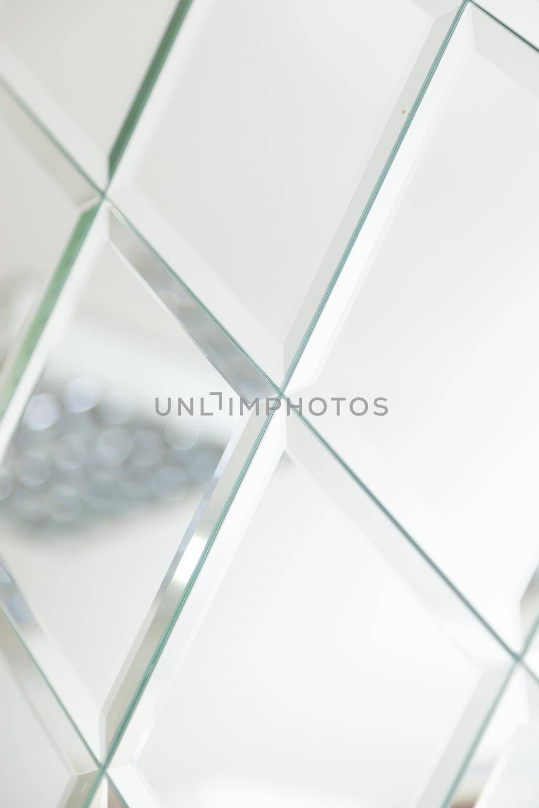 Mirror with crystals in wall, decoration and reflection. Abstract glass background. Polygonal surface. Close-up.