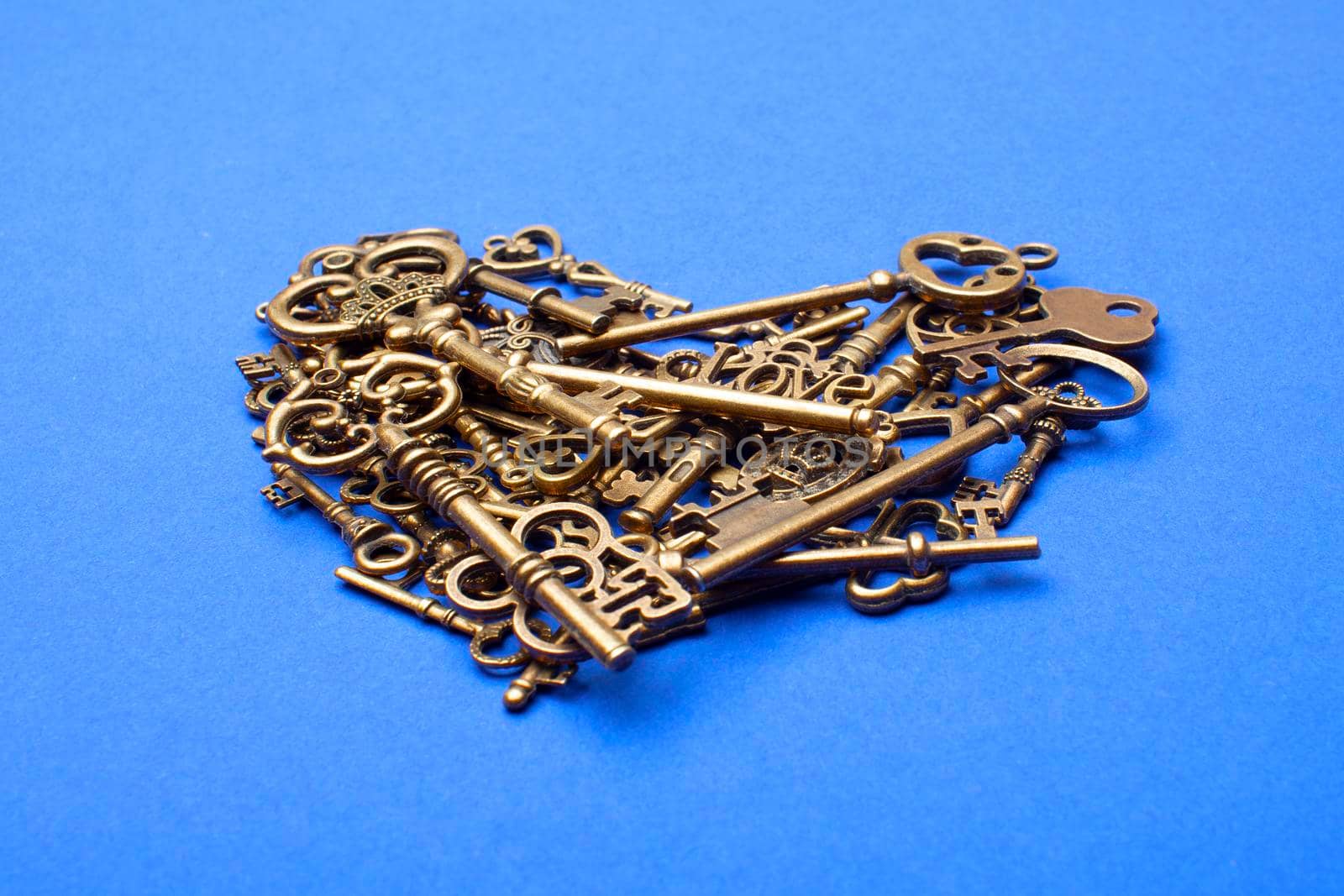 Old, vintage keys in the shape of a heart isolated on blue bacground