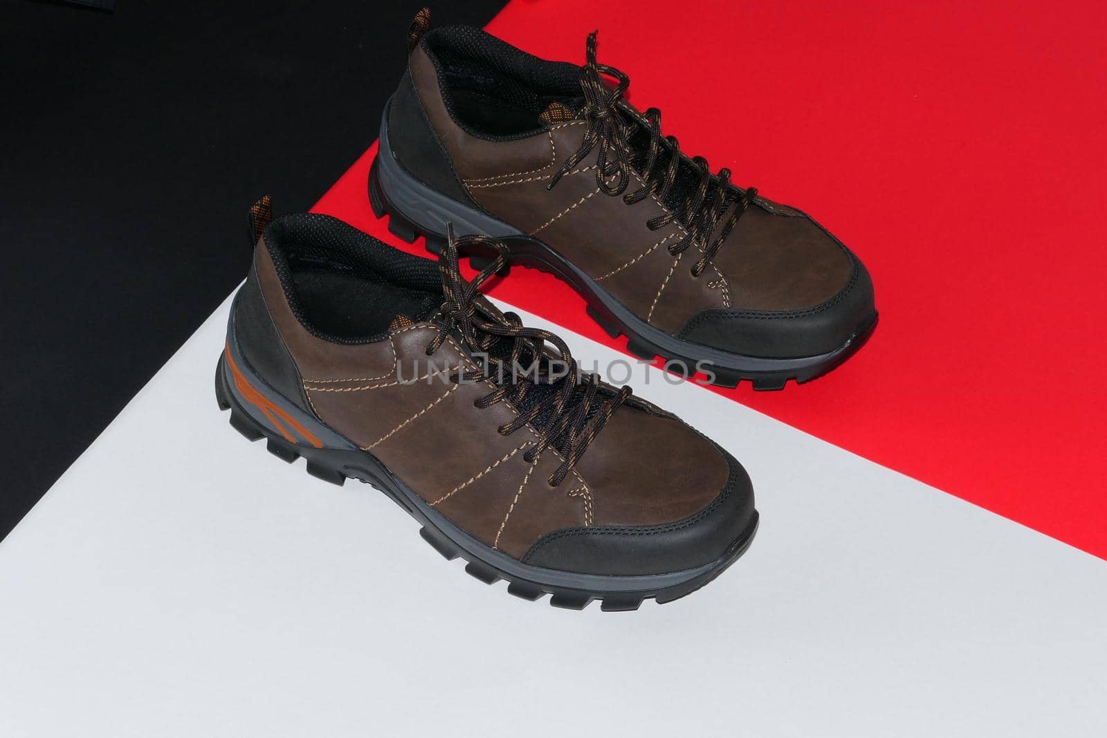 Stylish men's sneakers or leather brown shoes on a colored background.