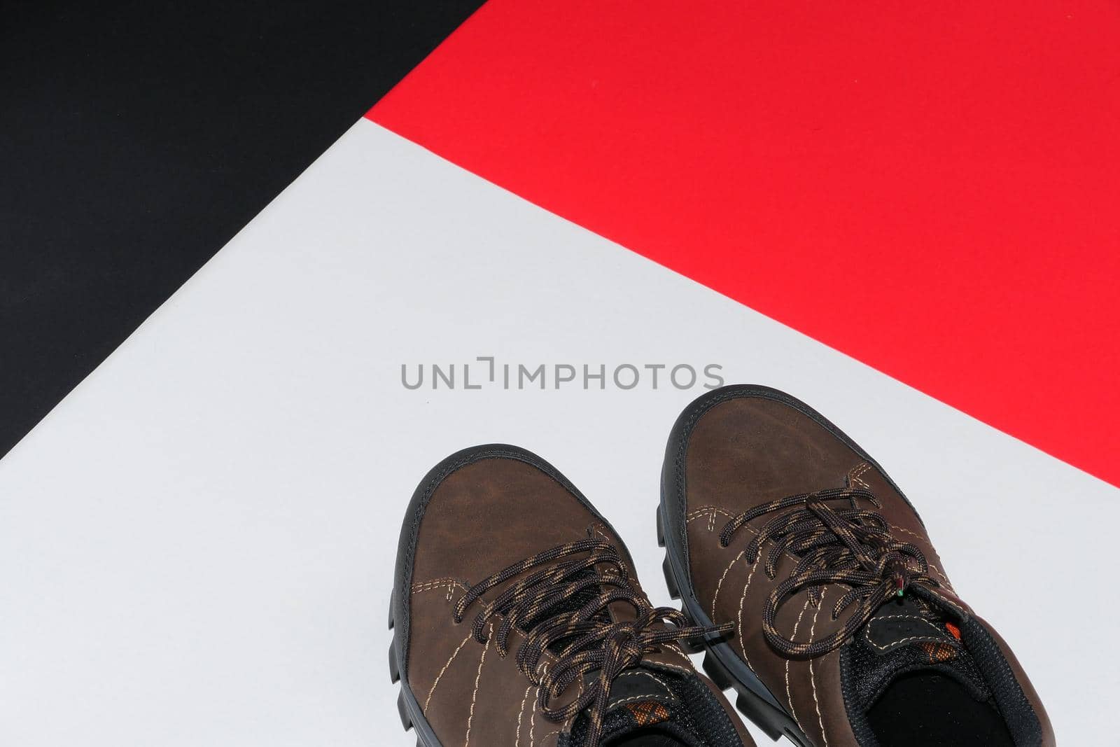 Stylish men's sneakers or leather brown shoes on a colored background.